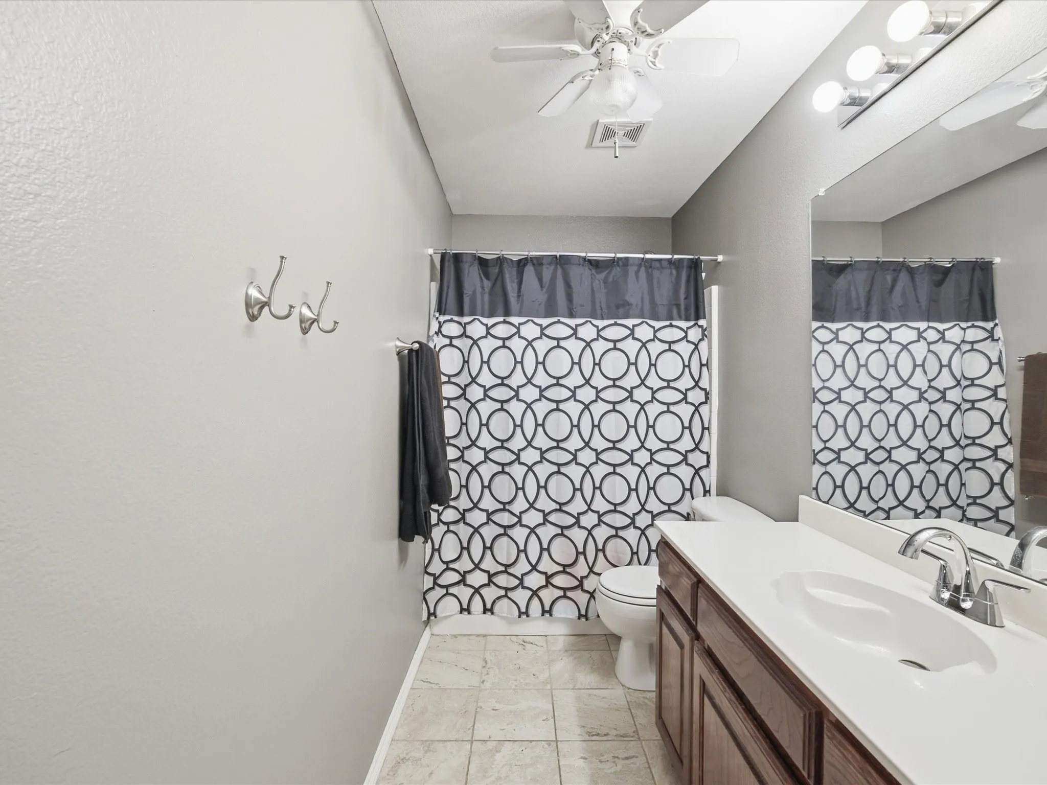 Vanity with a white countertop and integrated sink, chrome faucet, and dark wood cabinetry