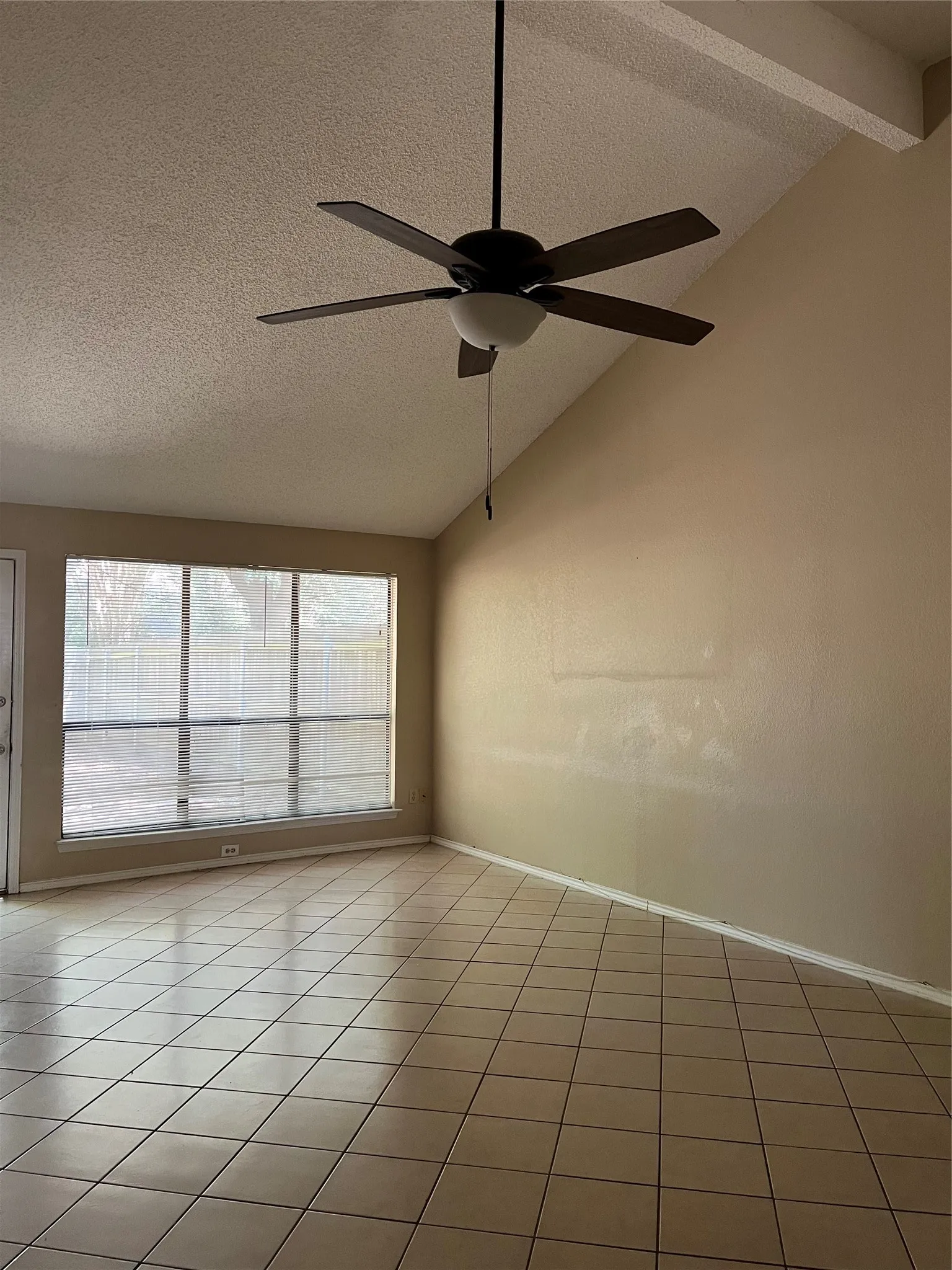 Vaulted ceiling with exposed beam and ceiling fan