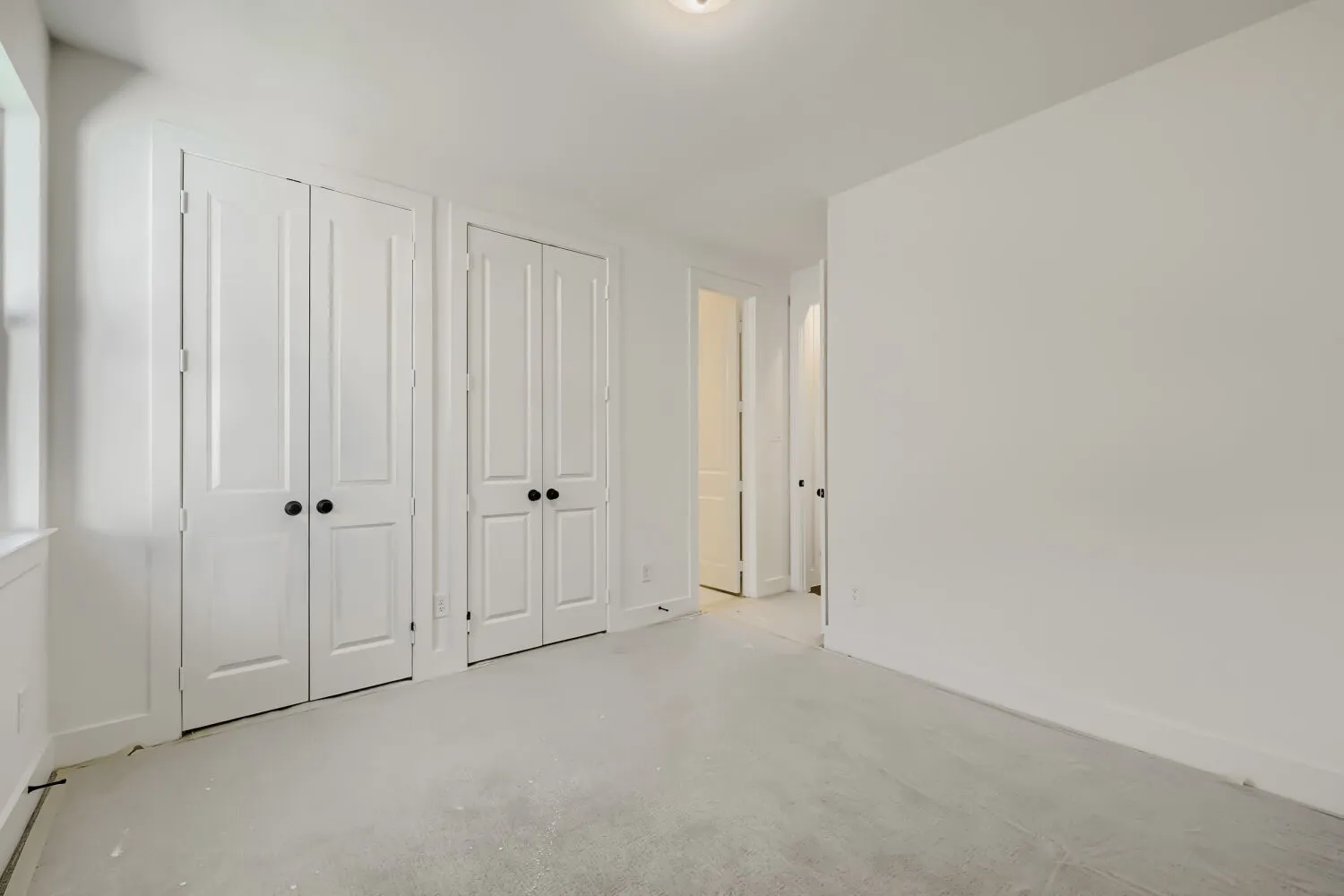 Room featuring light-toned carpeting, white walls, and a recessed ceiling light