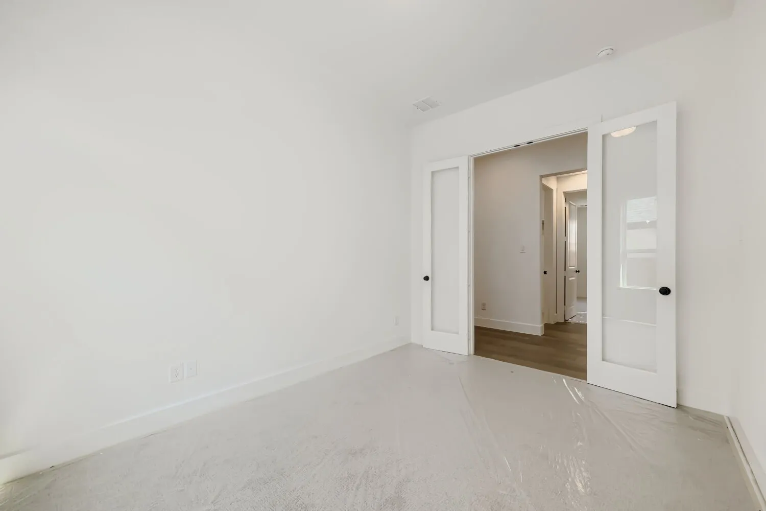 Interior room with white walls, white trim, and a high ceiling