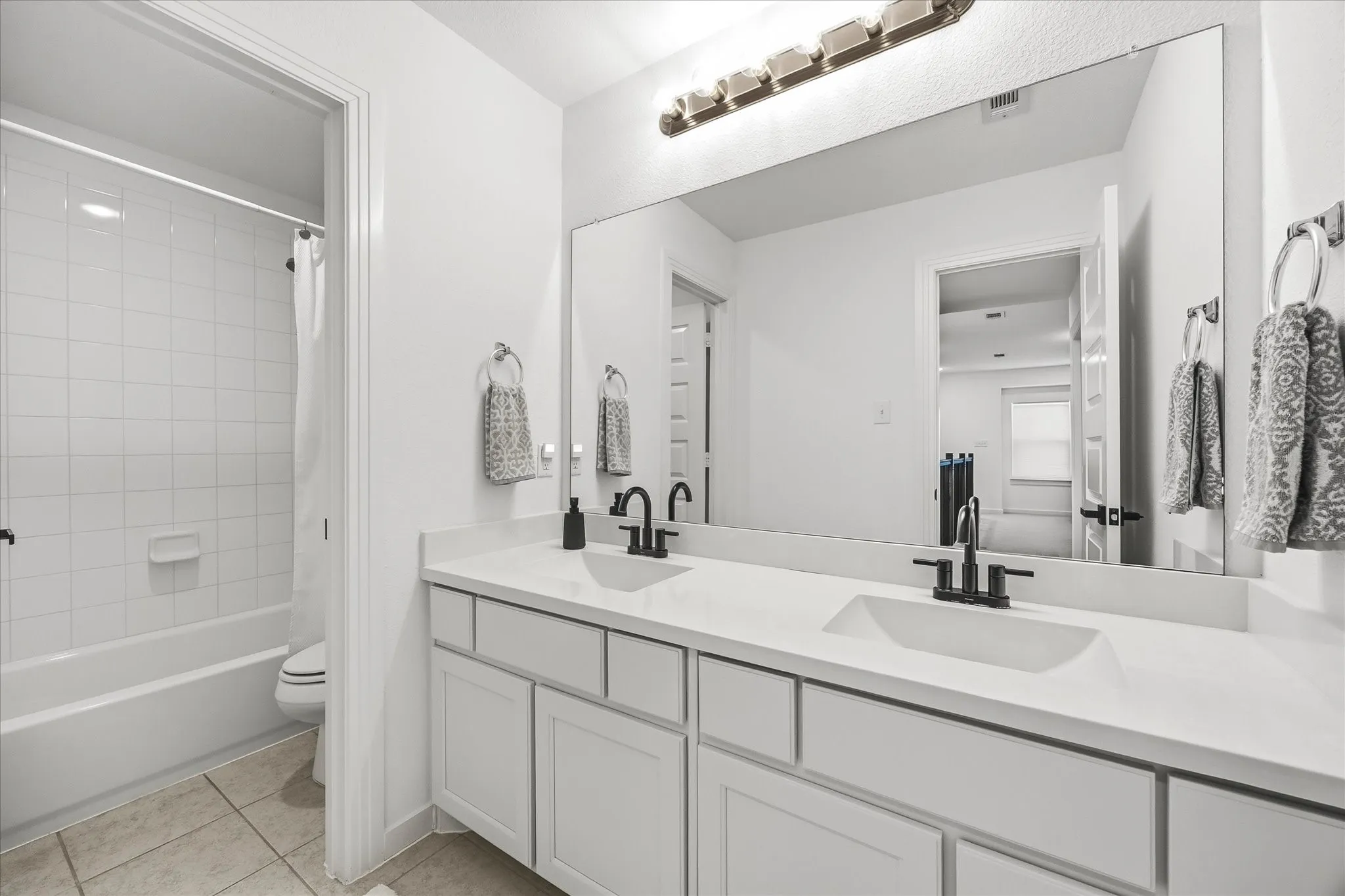 Auxiliary full bath features double vanities