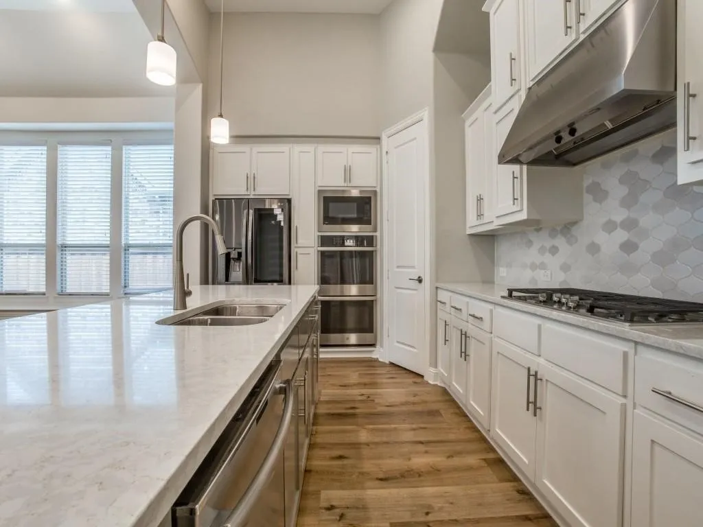 Kitchen featuring a large island with an undermount sink and gooseneck faucet