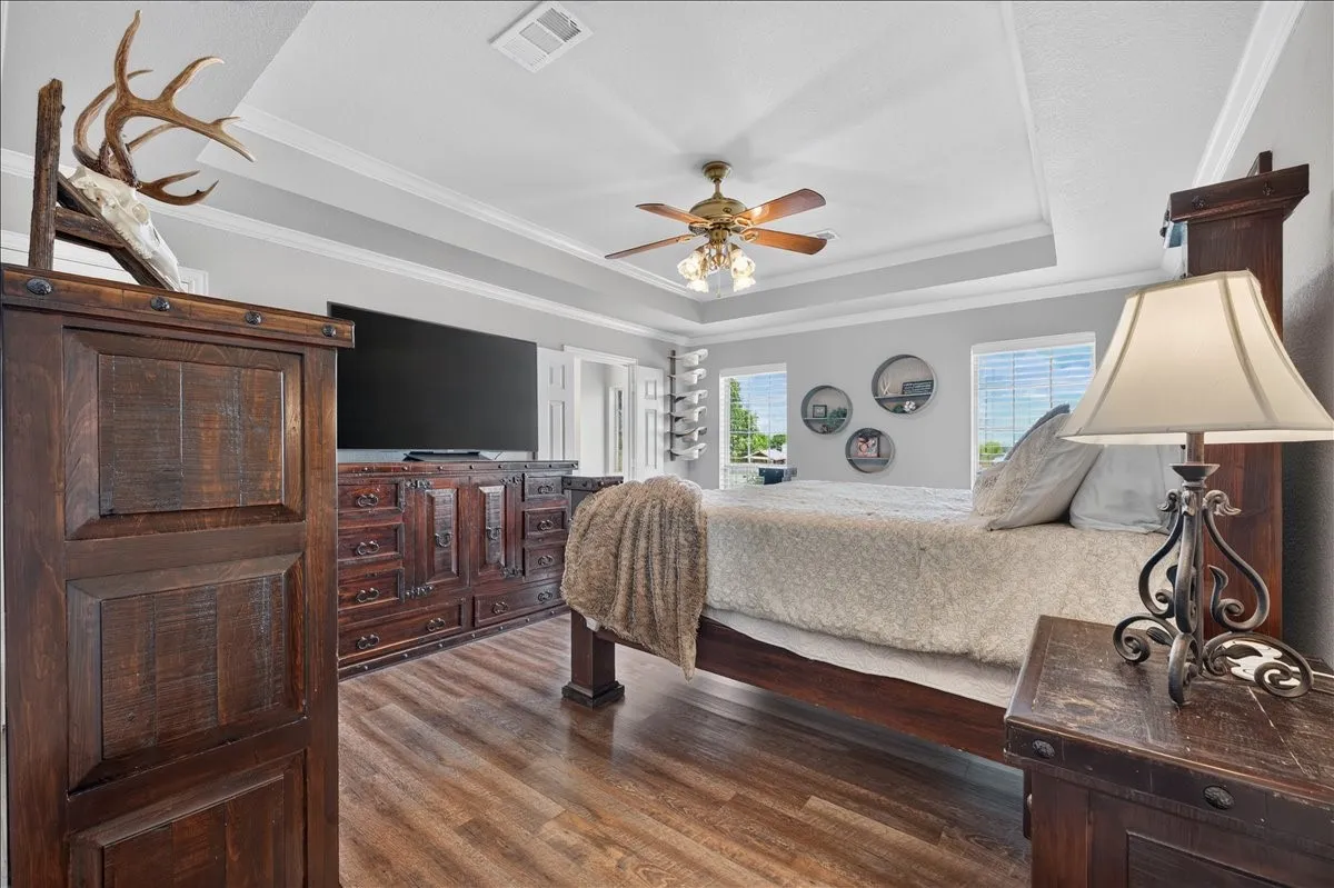Large primary with tray ceiling and a ceiling fan with an ensuite bathroom