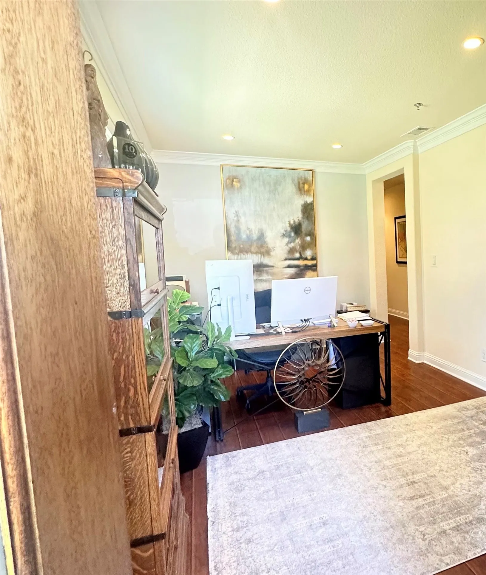 Hardwood-style flooring throughout with recessed lighting and crown molding