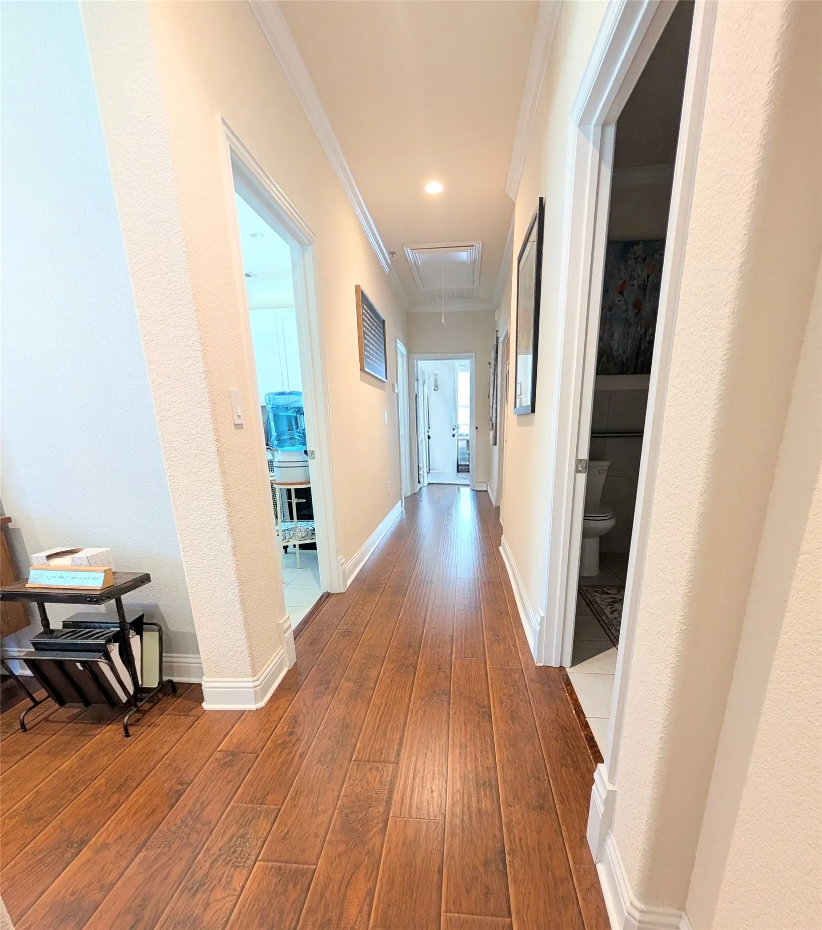 Hallway with wood-finish flooring, recessed lighting, and crown molding