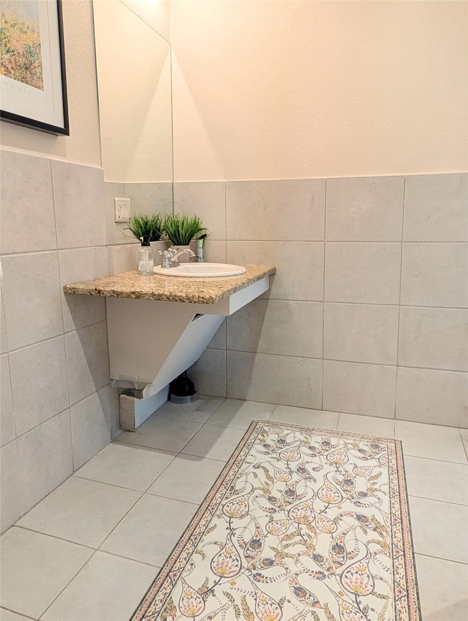 Floating vanity with a speckled countertop and integrated basin sink