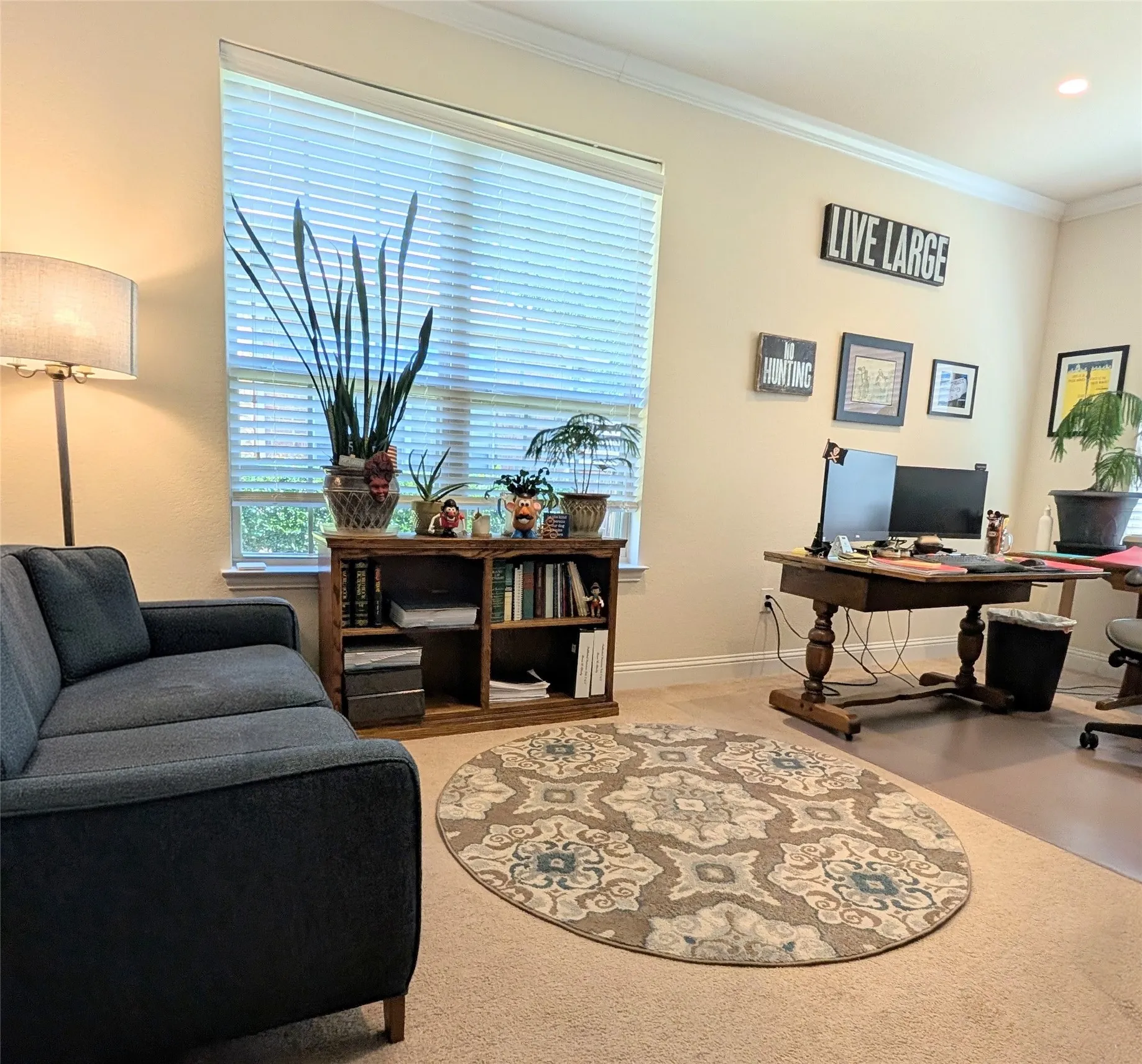 Spacious room with crown molding and light-toned carpet flooring
