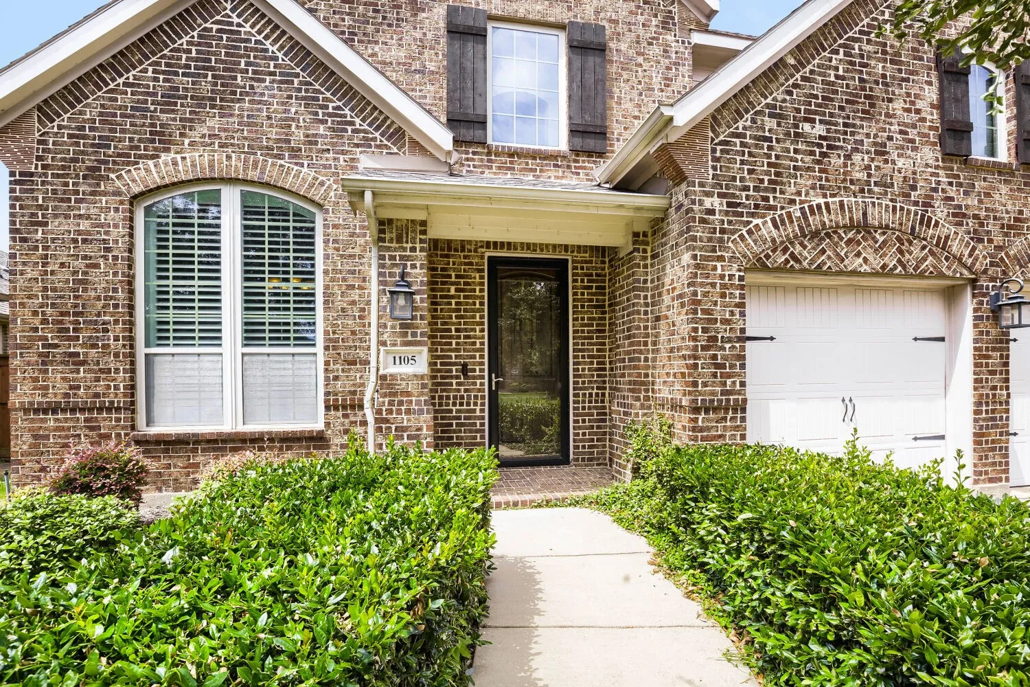Brick facade with architectural window features and decorative shutters