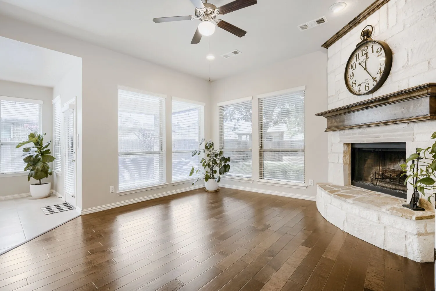 Living space featuring rich wood-finish flooring and a stone-clad fireplace with a substantial wood mantel