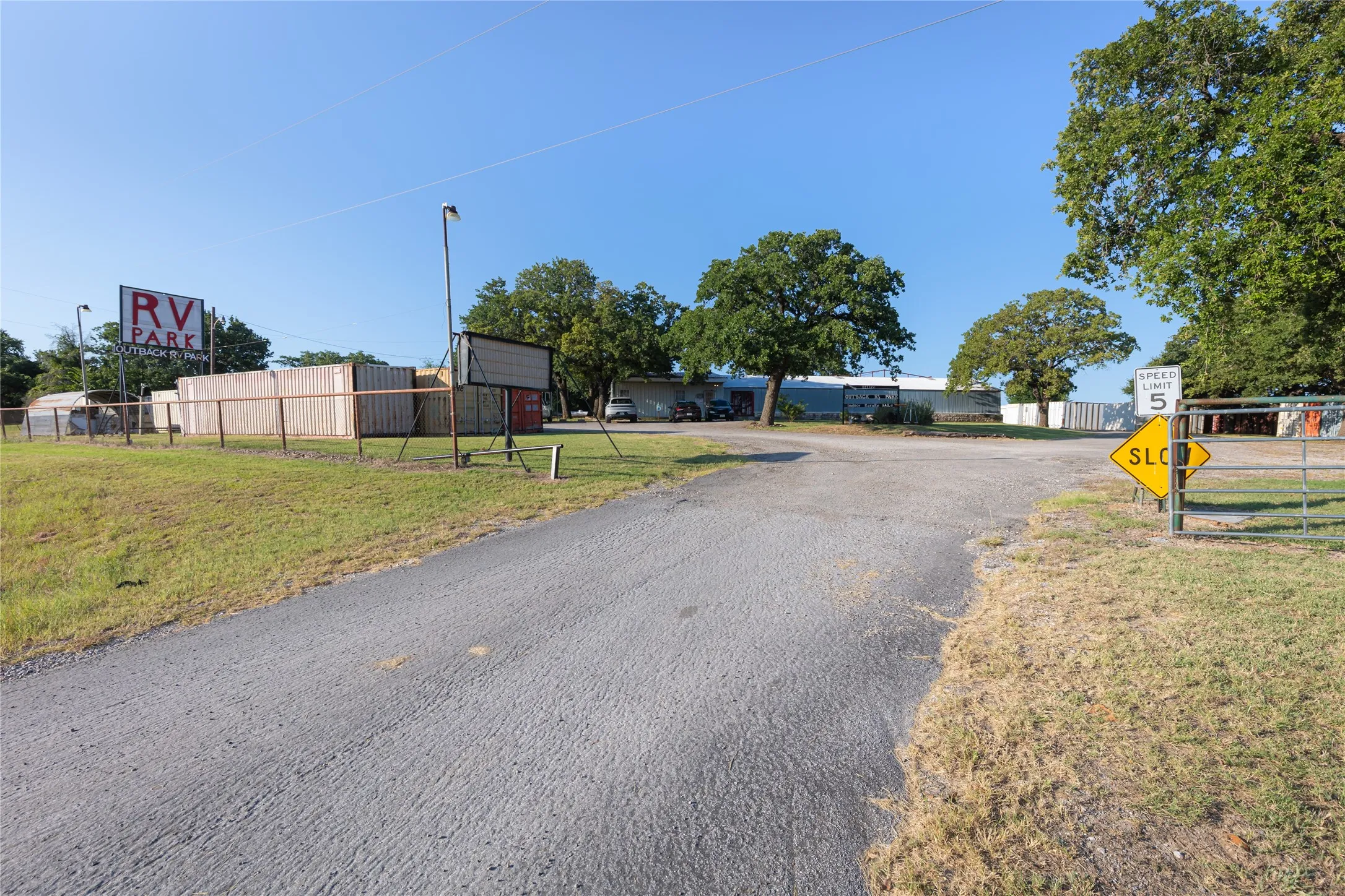 Paved driveway entry with speed limit signage and an RV Park sign