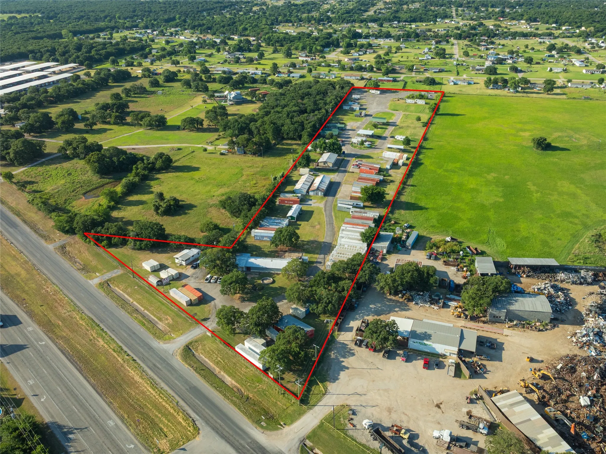 Expansive land parcel featuring multiple structures and direct road frontage