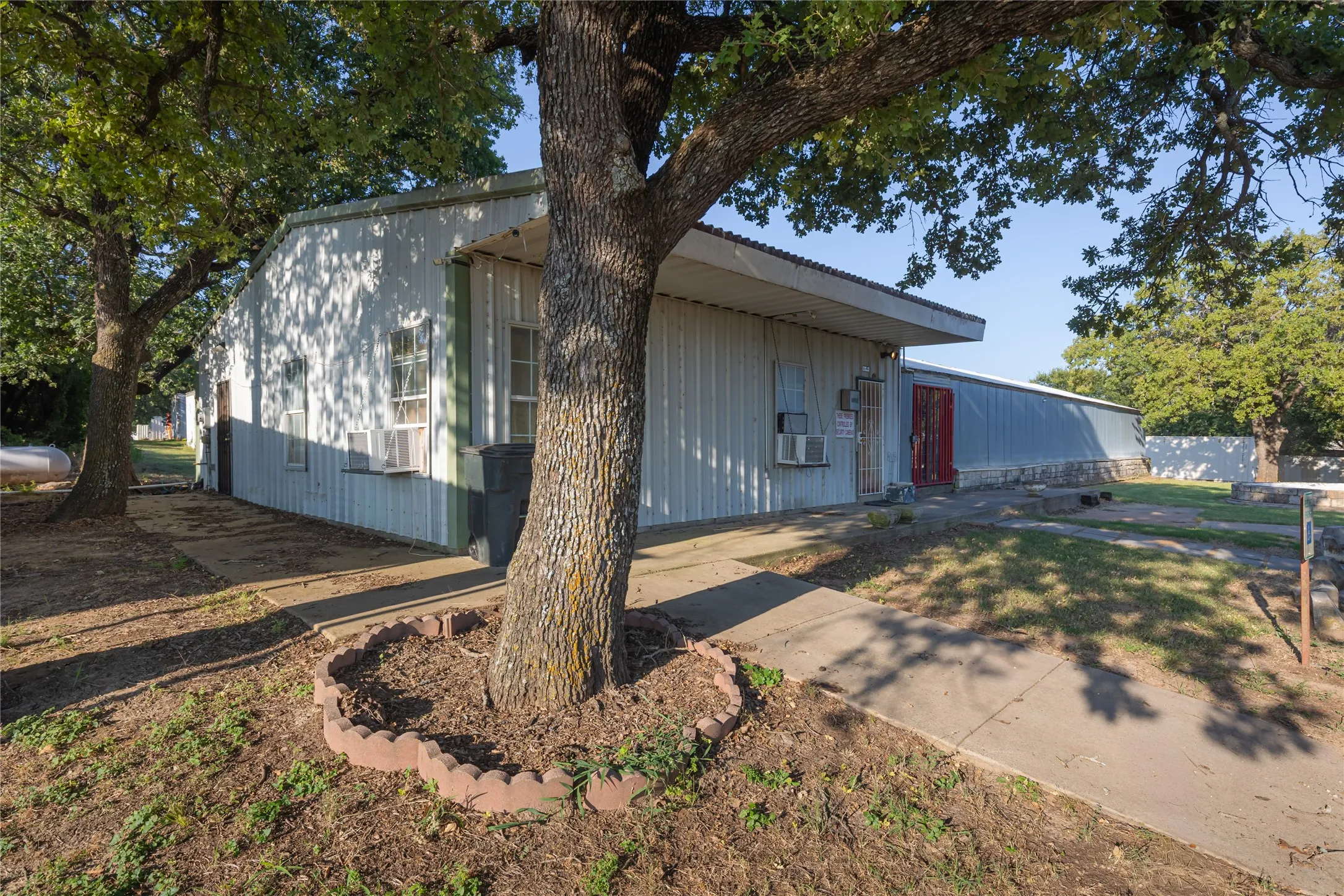 Exterior building with corrugated metal siding, multiple windows, and a covered entrance