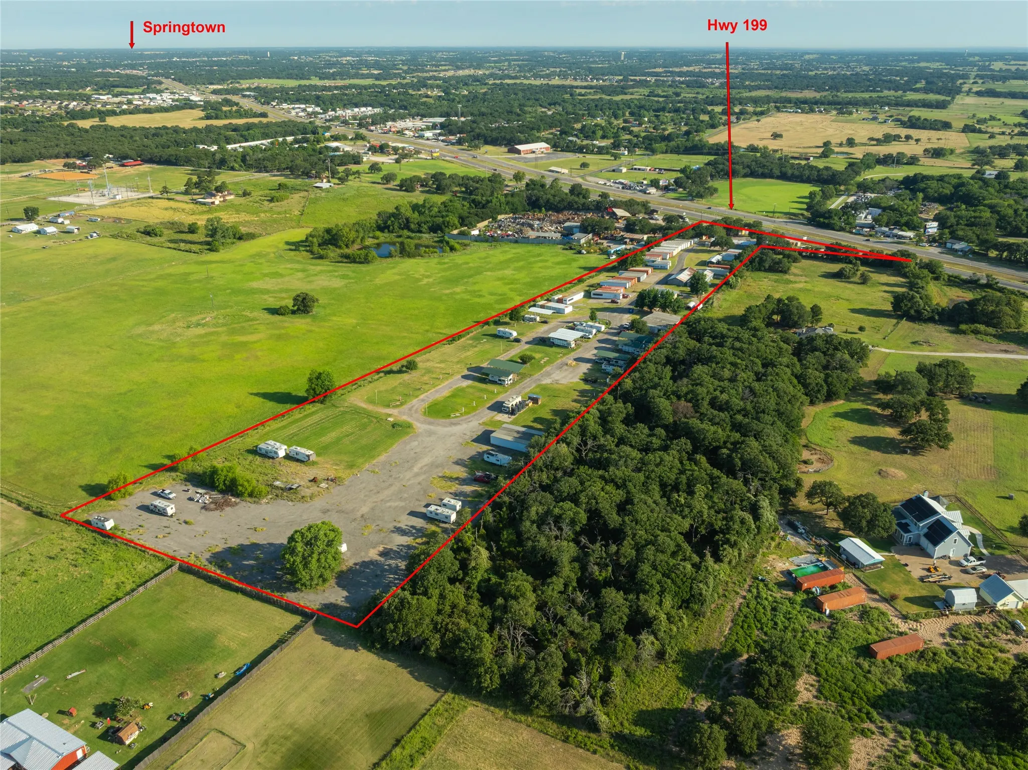 Expansive land parcel featuring direct highway frontage and extensive tree coverage