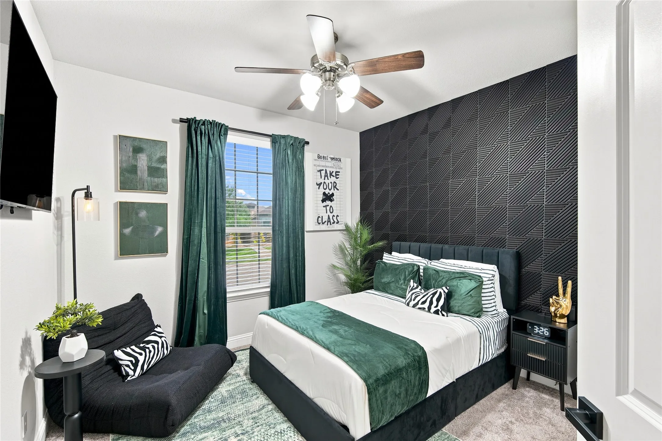 Bedroom featuring a textured accent wall, a window with blinds, and a ceiling fan with integrated lighting