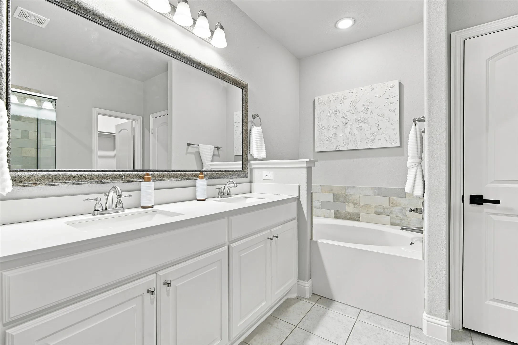 Double vanity with integrated sinks, framed mirror, and chrome fixtures