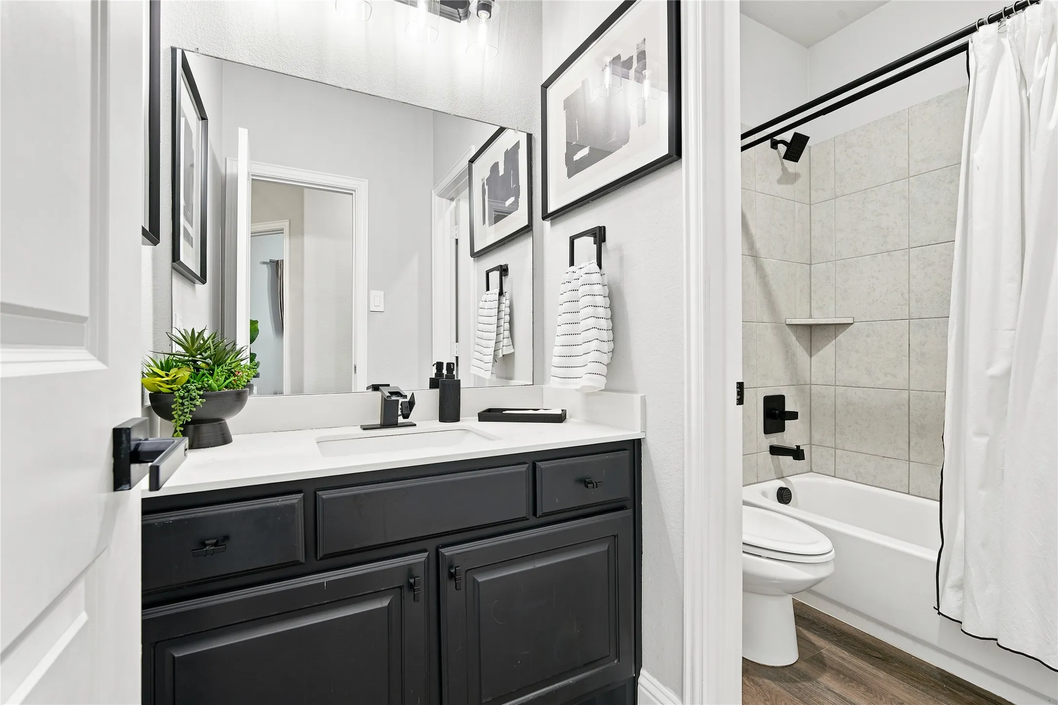 Bathroom featuring a dark wood vanity with a white countertop, undermount sink, and black fixtures
