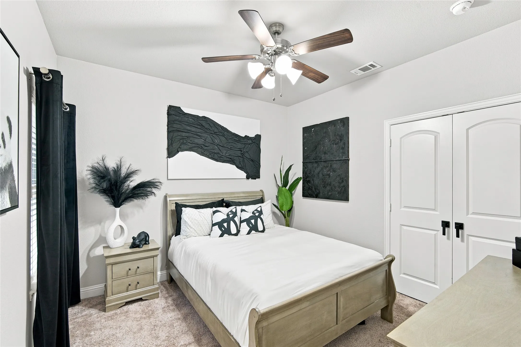 Bedroom featuring a textured accent wall, a window with blinds, and a ceiling fan with integrated lighting
