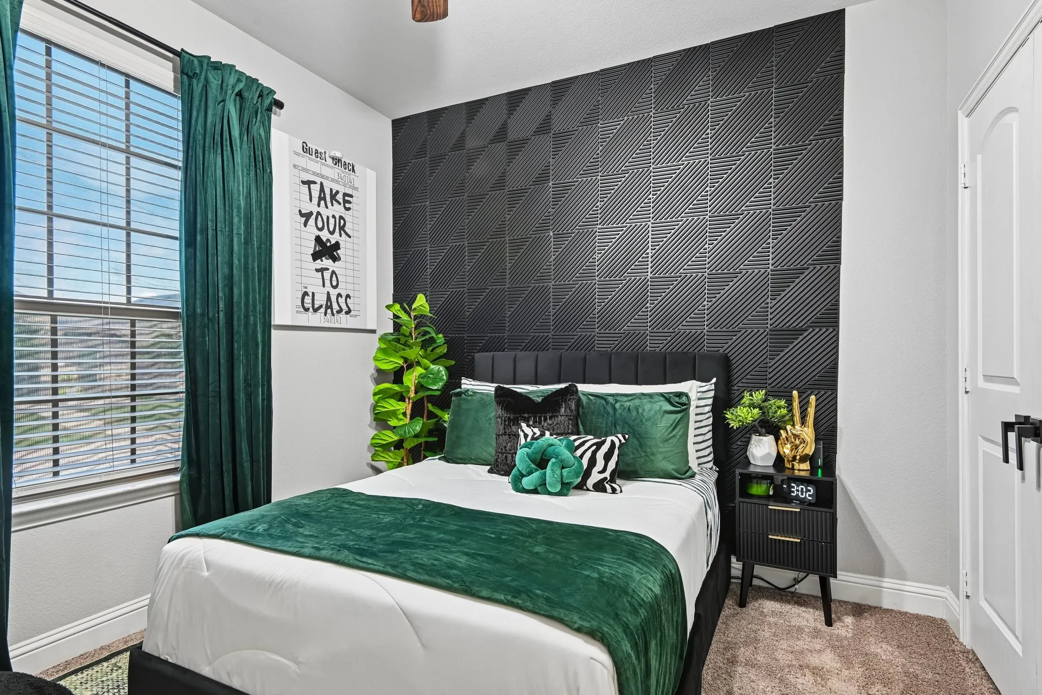 Textured accent wall, plush carpeting, window with blinds, and a built-in ceiling fan