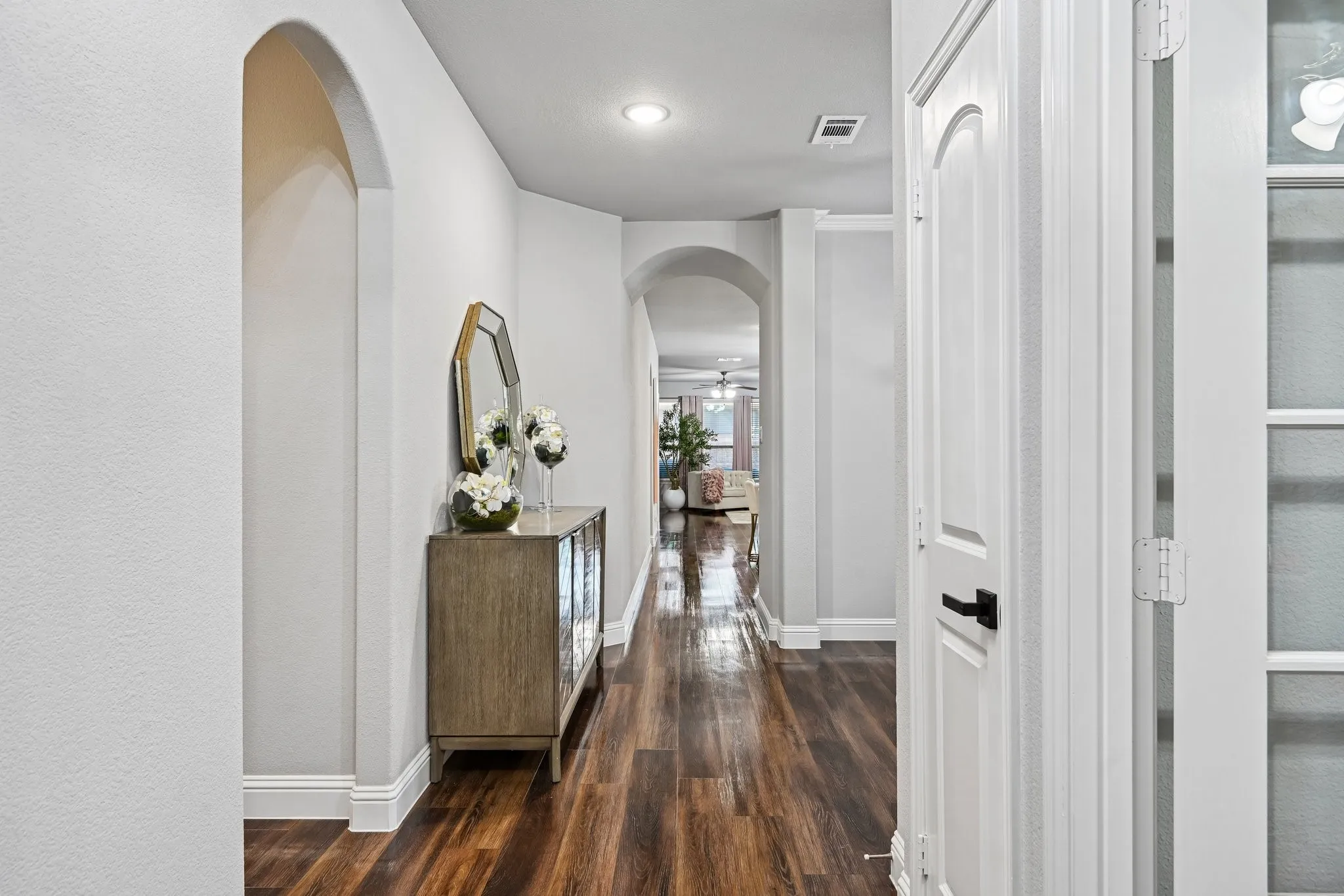 Hallway with wood-finish flooring and archway architectural details