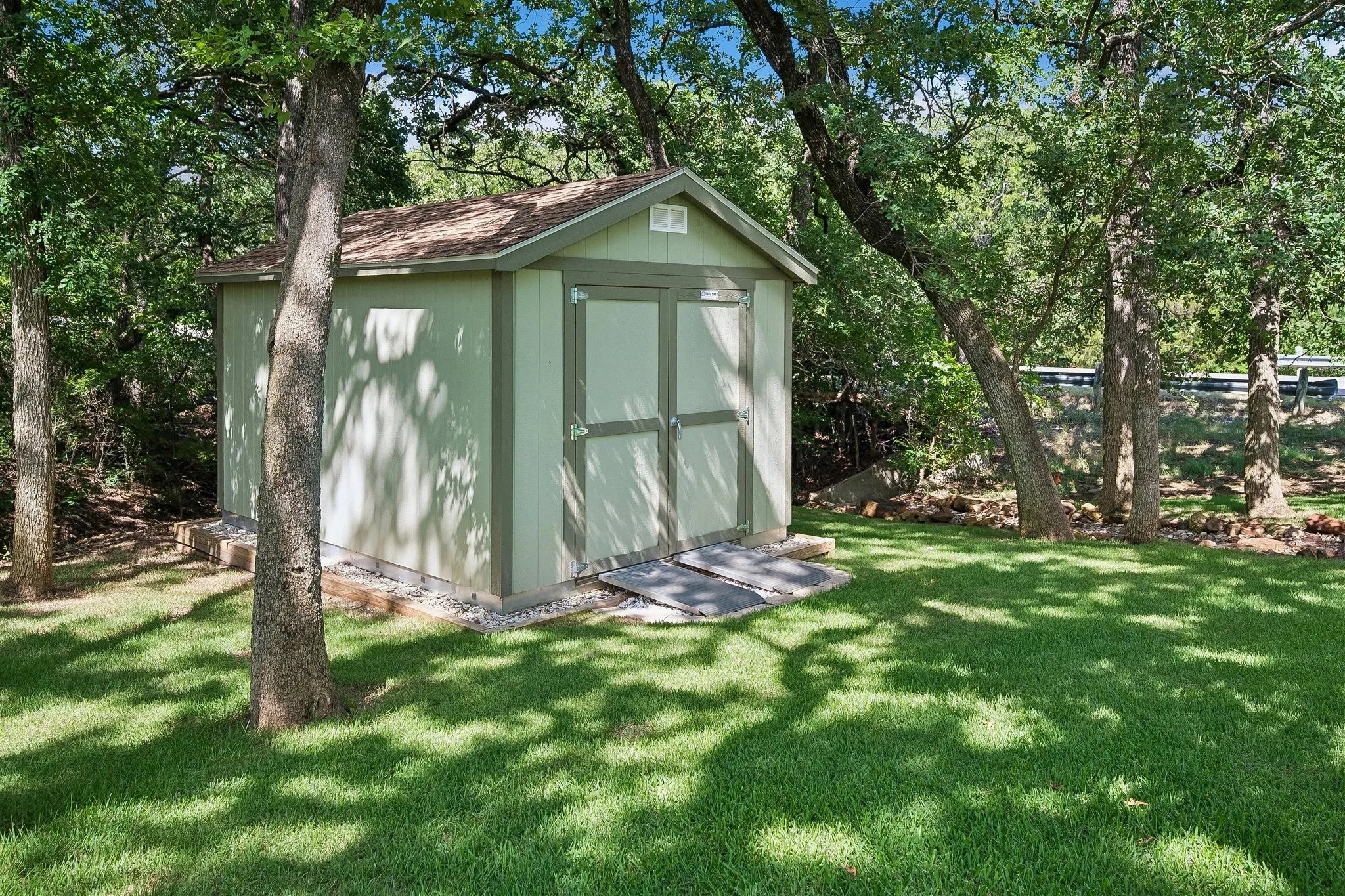 12' x 16' tool shed with aluminum ramps will convey with the property