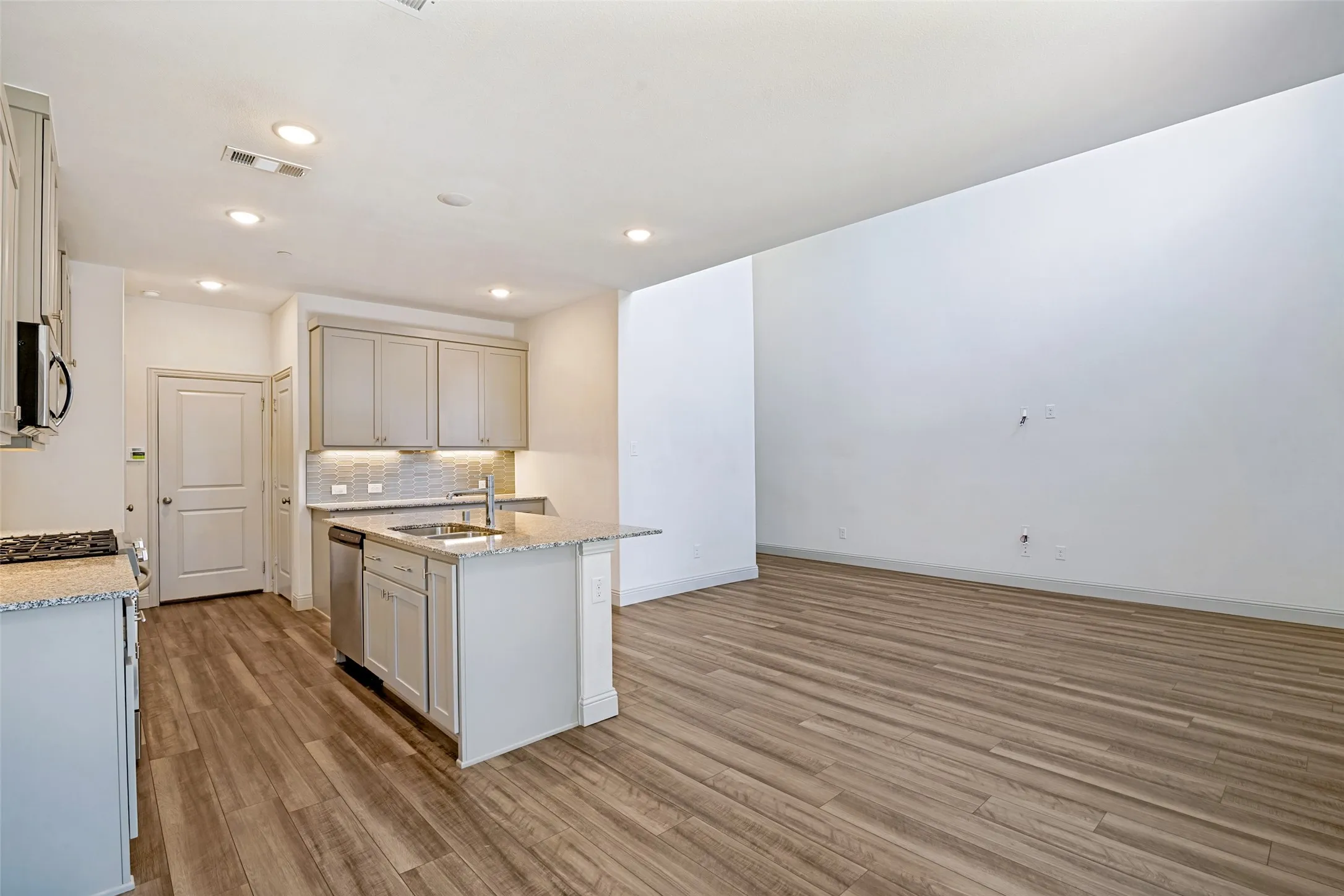 Kitchen island with built-in sink, stainless steel dishwasher, and bar seating