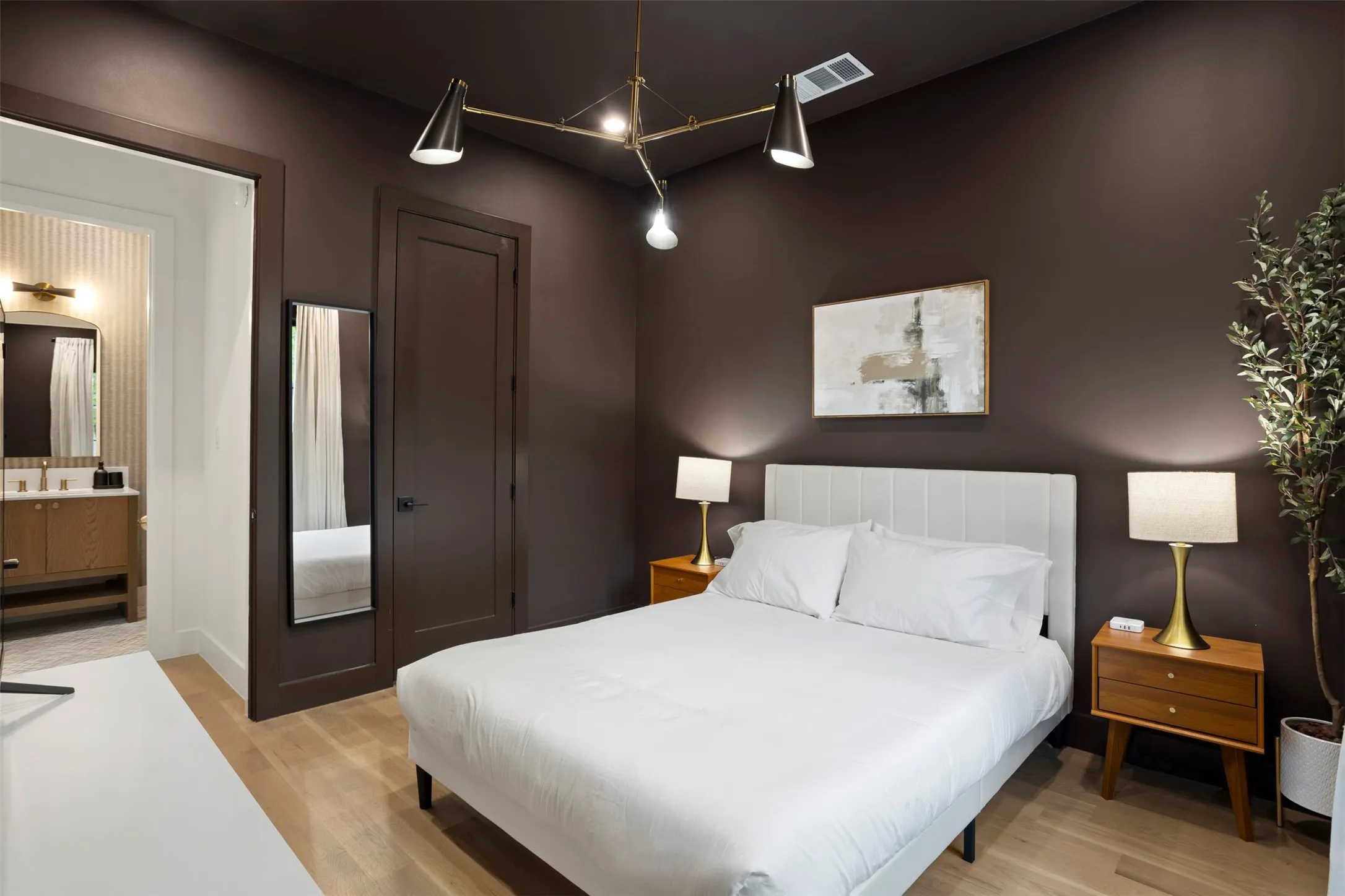 Bedroom with wood-finish flooring and deep brown walls