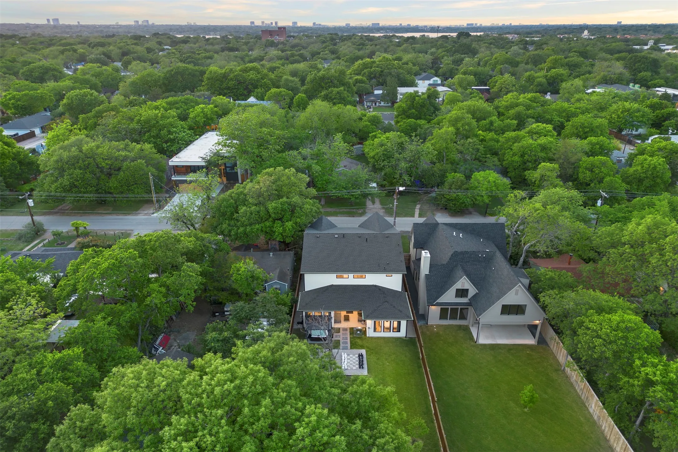 Aerial perspective showcasing two adjacent properties within a tree-lined neighborhood