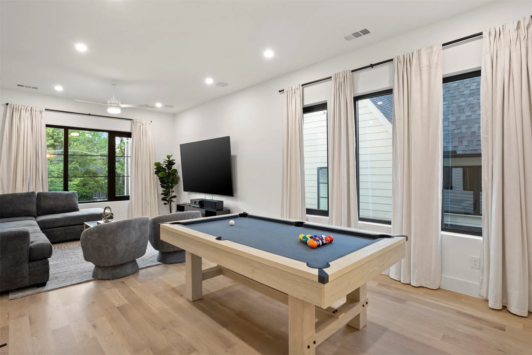 Recreational space featuring light wood-finish flooring and a ceiling fan with integrated lighting