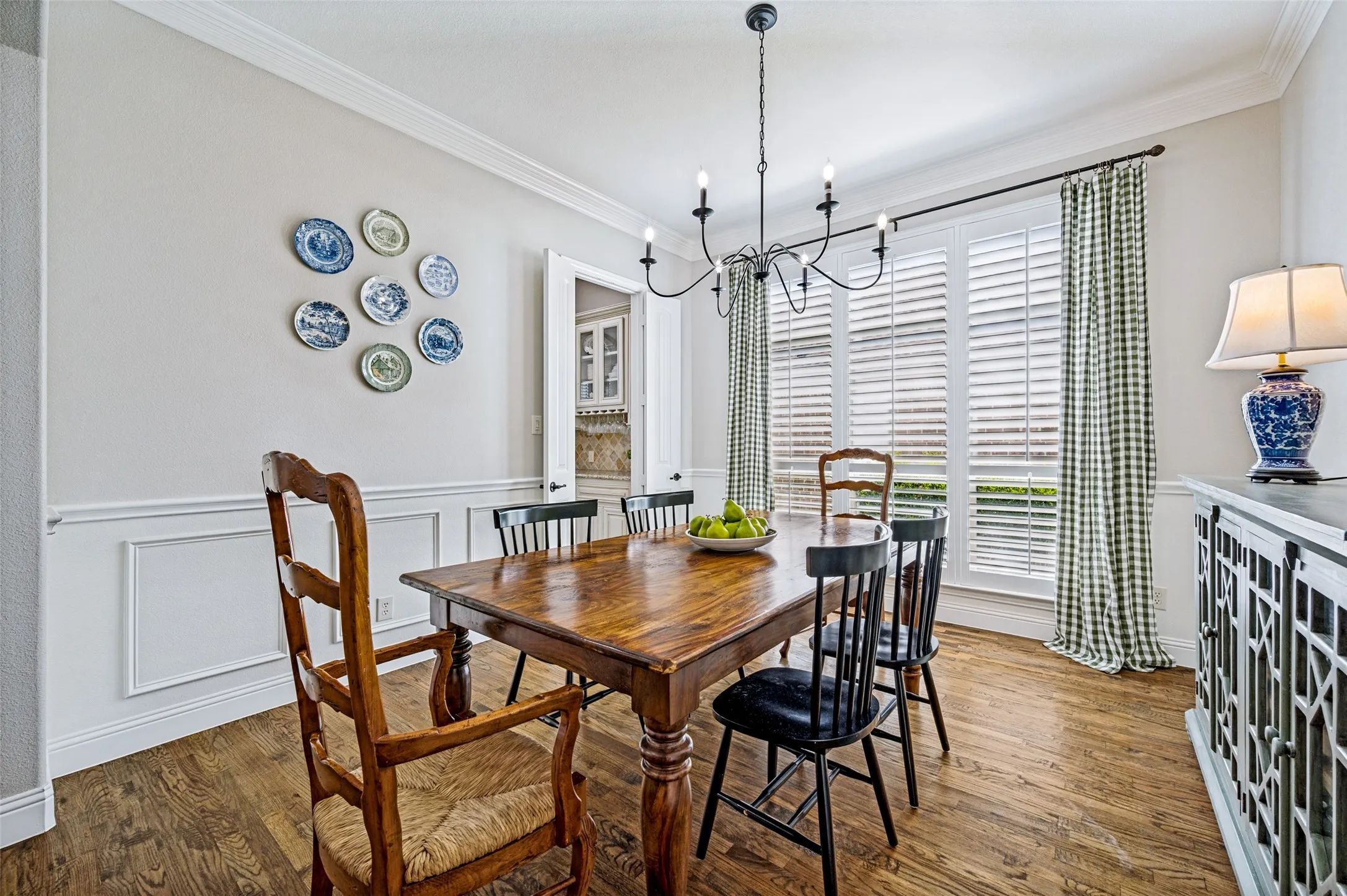 Formal living room with wood flooring and plantation shutters.