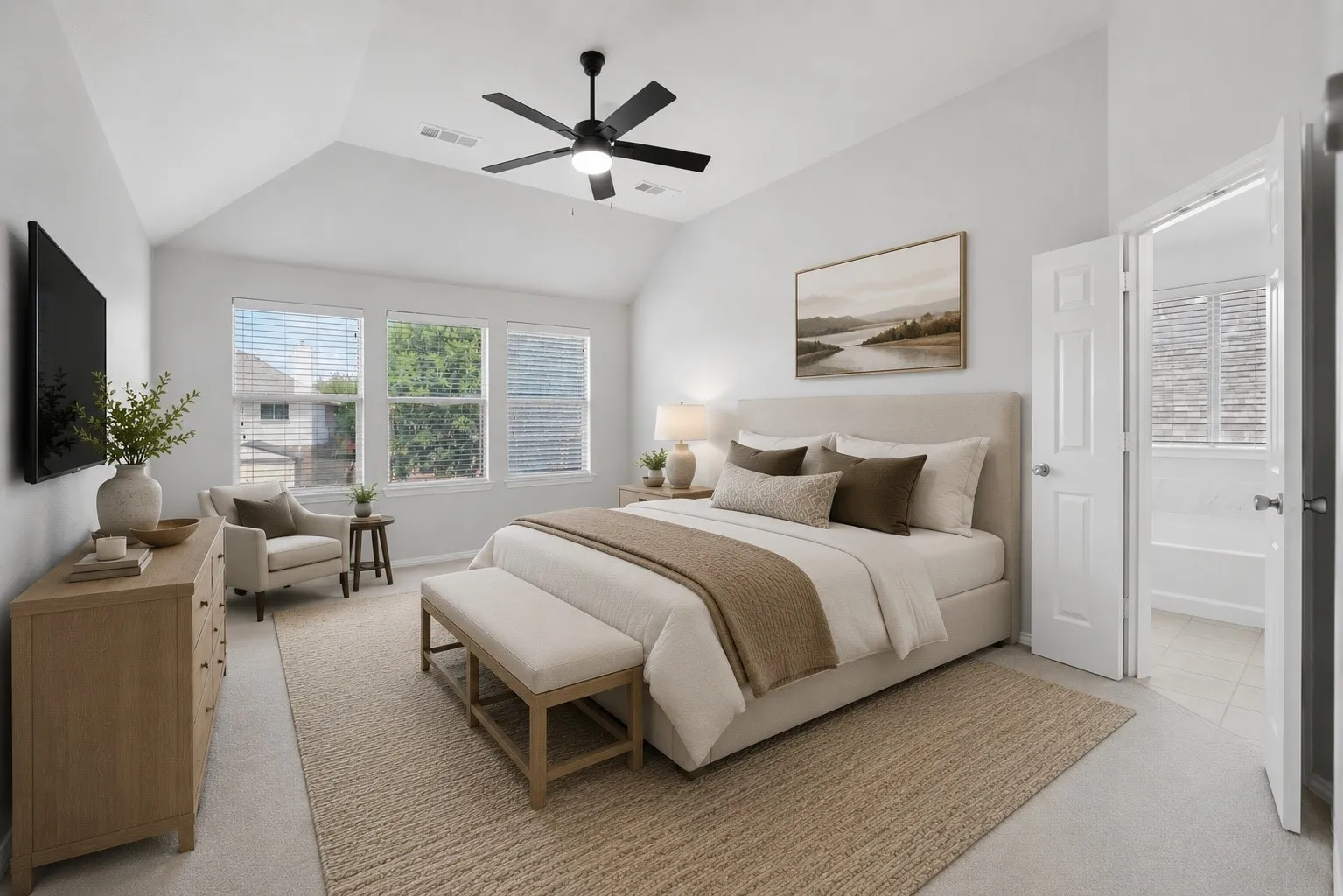 Spacious bedroom featuring a vaulted ceiling and a ceiling fan