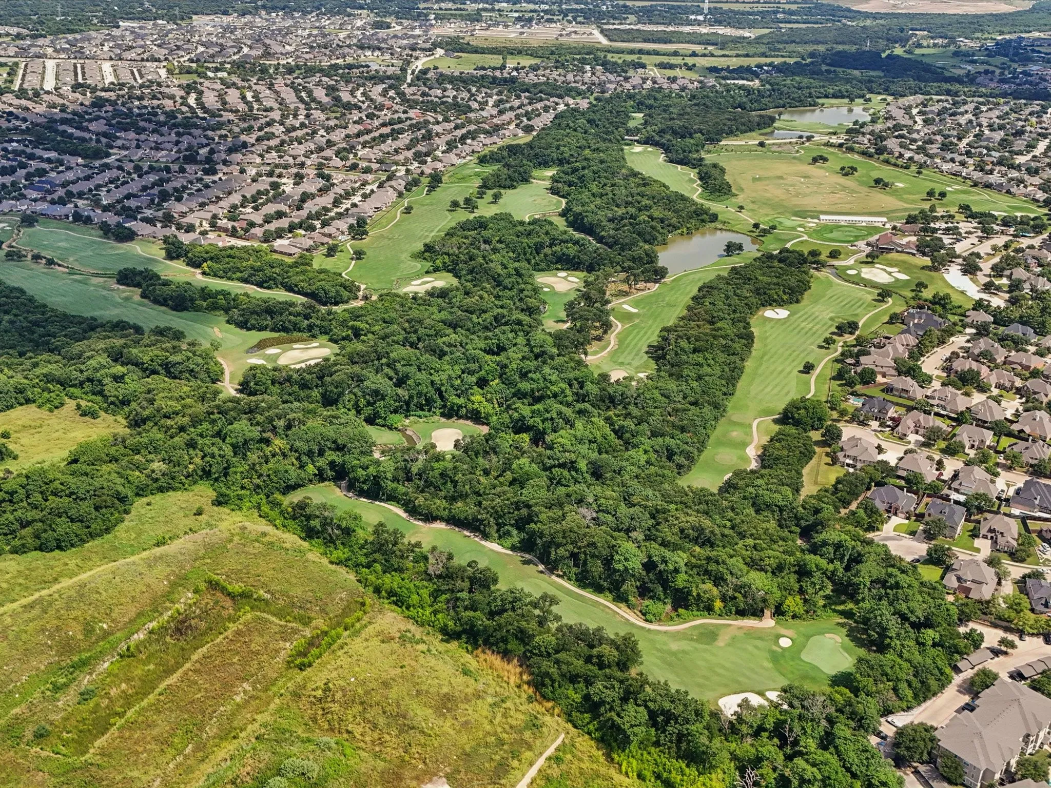 Expansive golf course setting featuring manicured greens and fairways