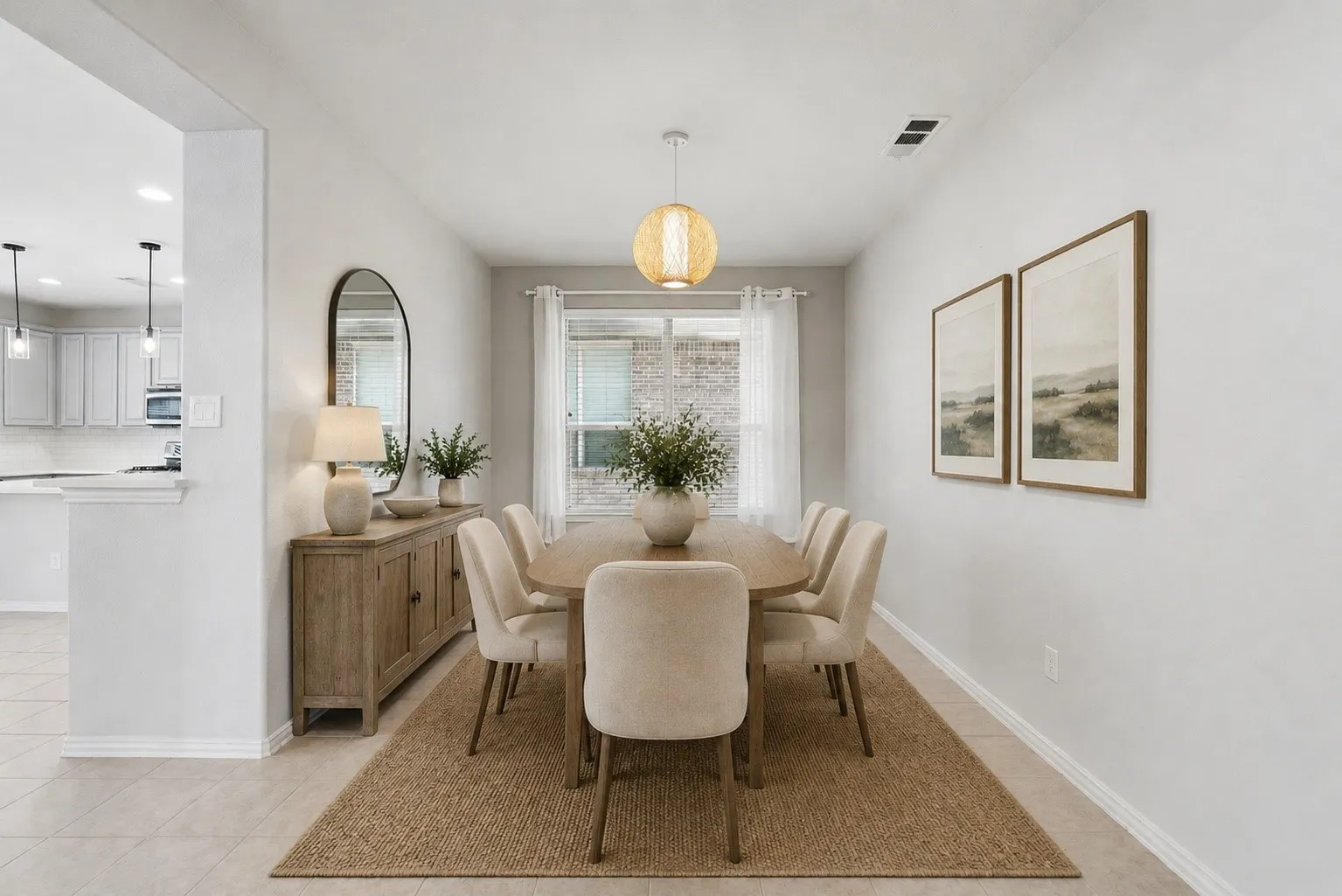 Dining area featuring light tile flooring, a woven pendant light fixture, and a window with white curtains