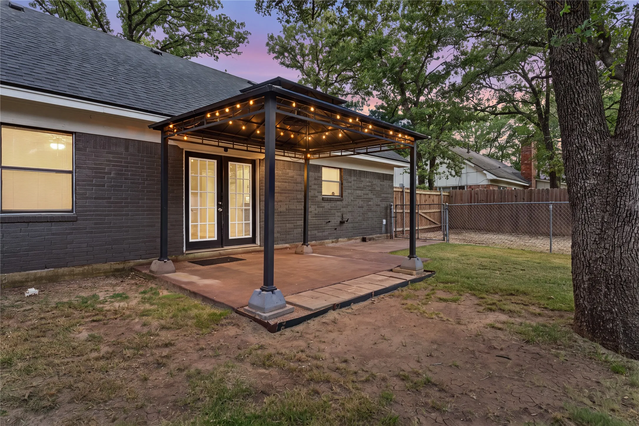 Covered patio with integrated string lighting, accessible via double French doors