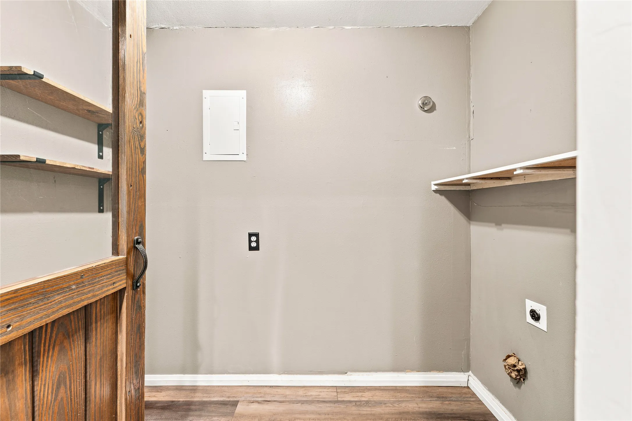 Interior space featuring wood-finish flooring, light gray walls, and white baseboards
