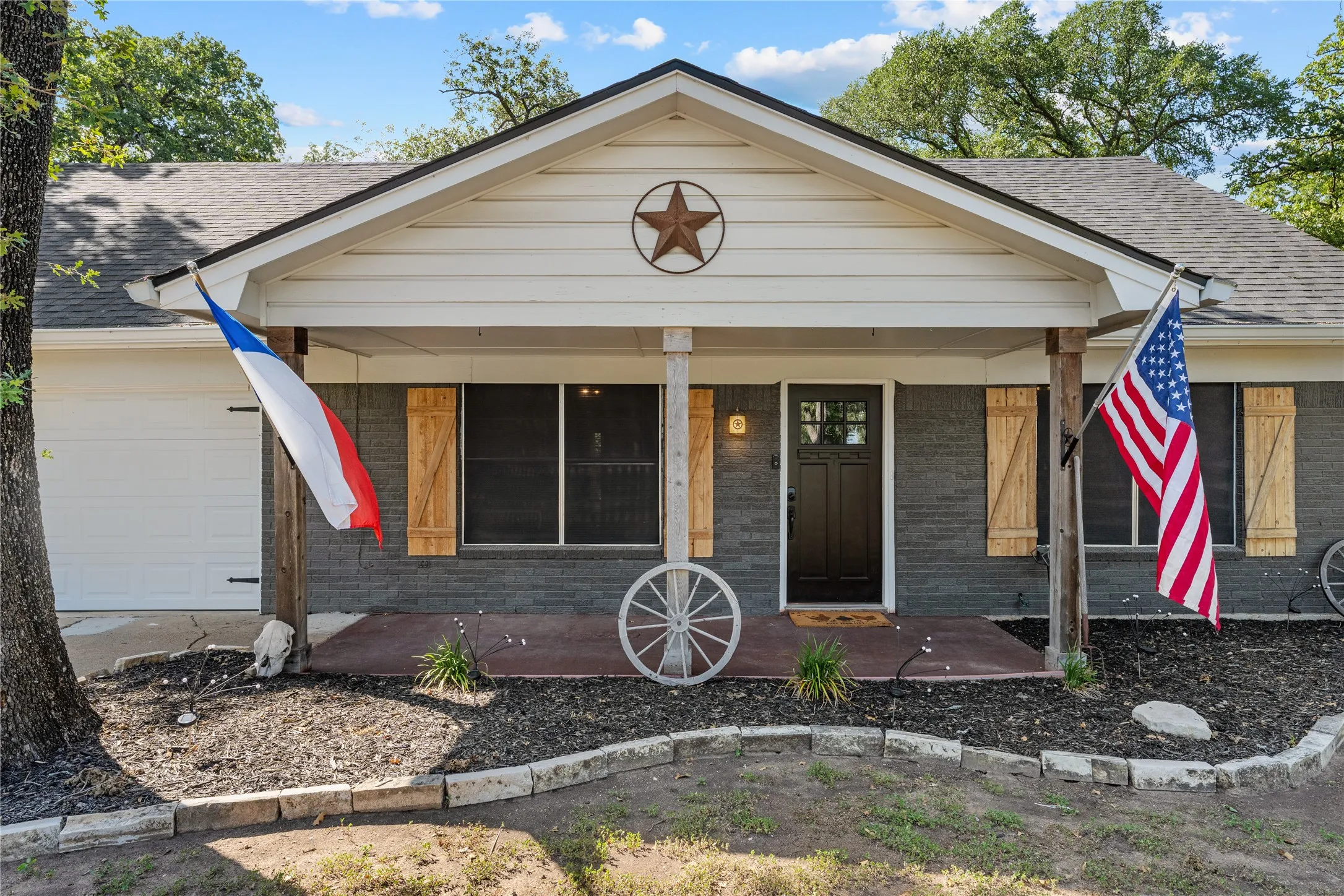 Inviting front porch with wood columns and a dark wood entry door