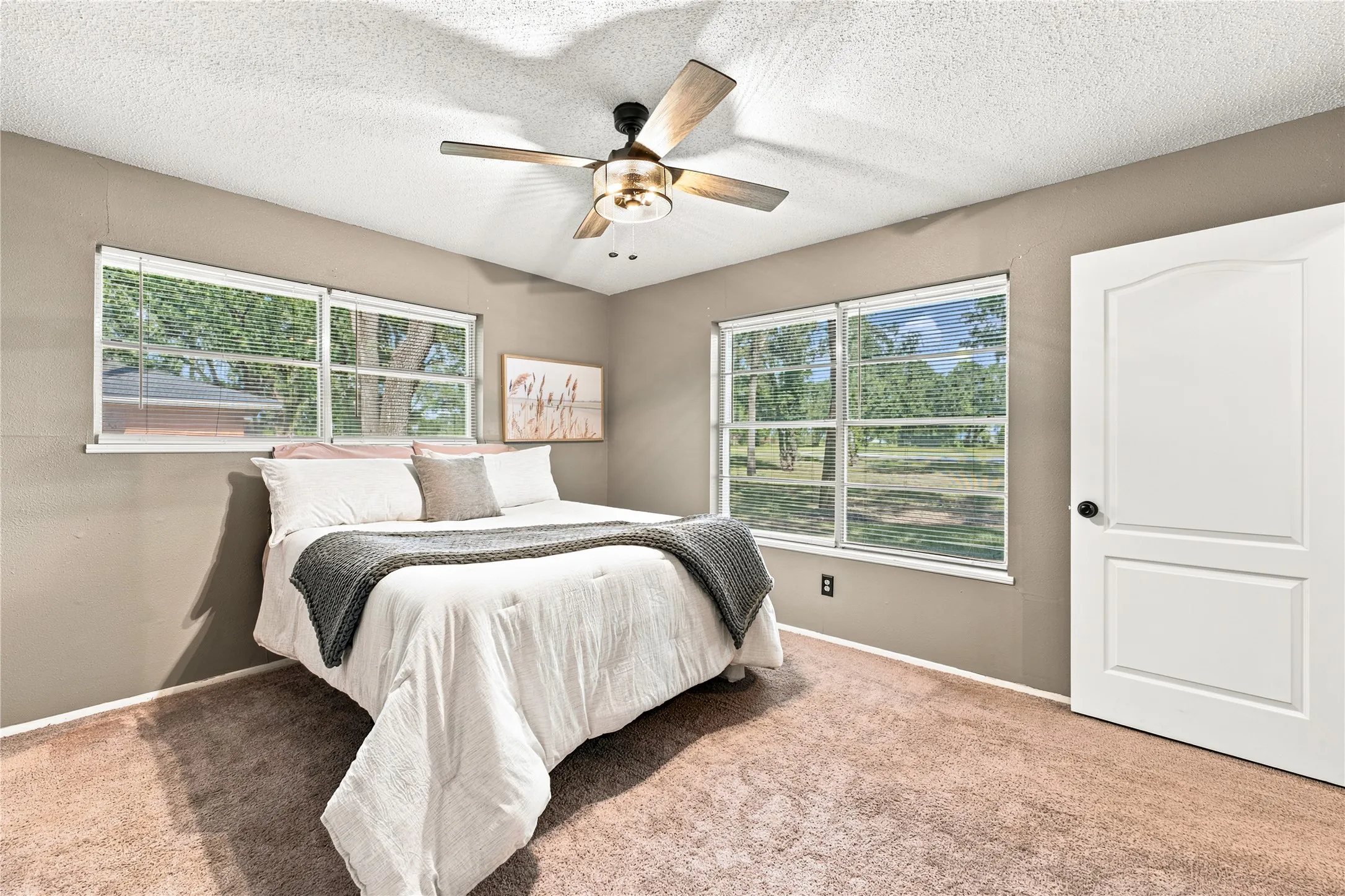 Bedroom with light brown carpet flooring and neutral wall tones
