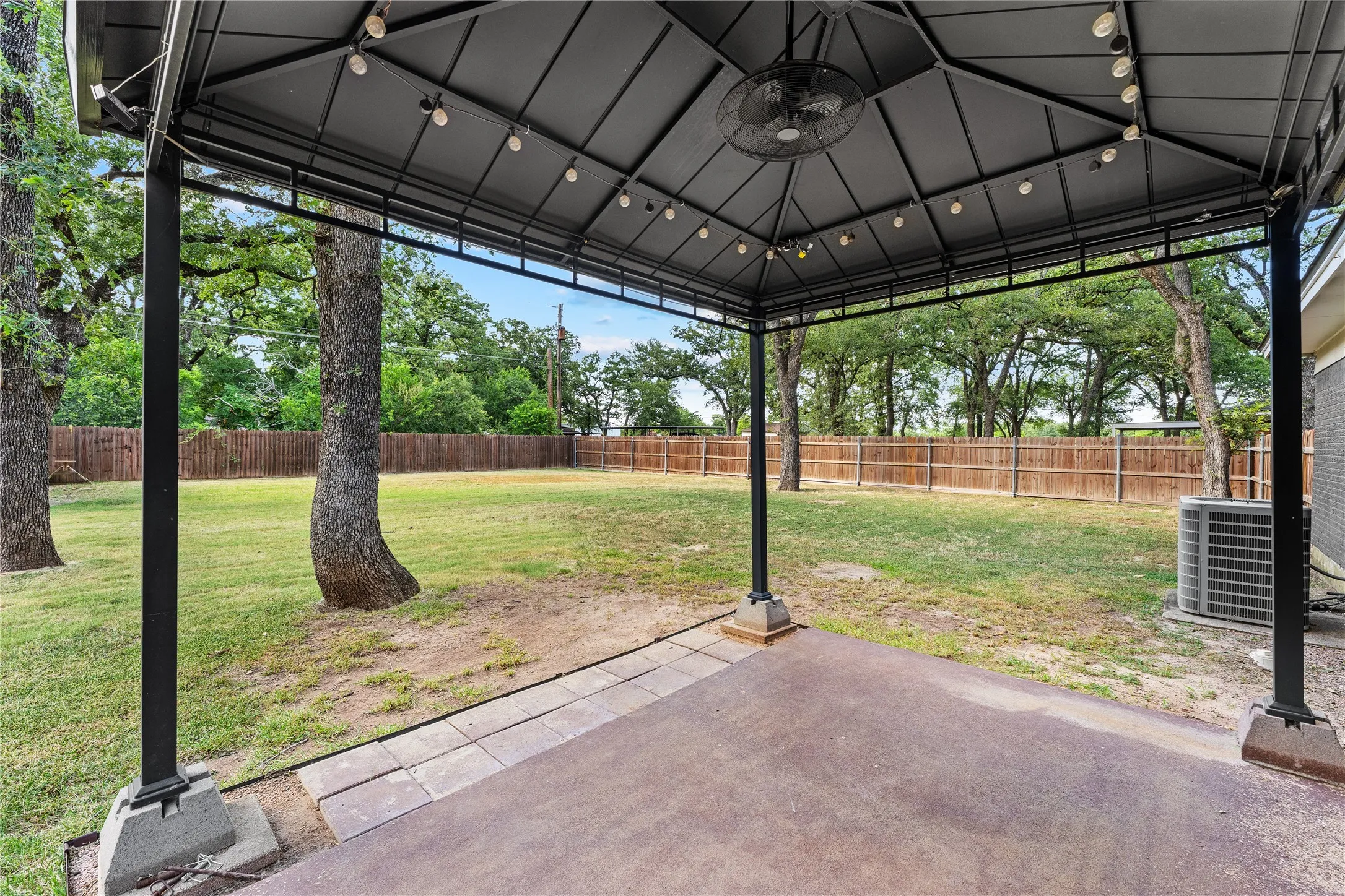 Covered patio with an integrated ceiling fan and string lighting