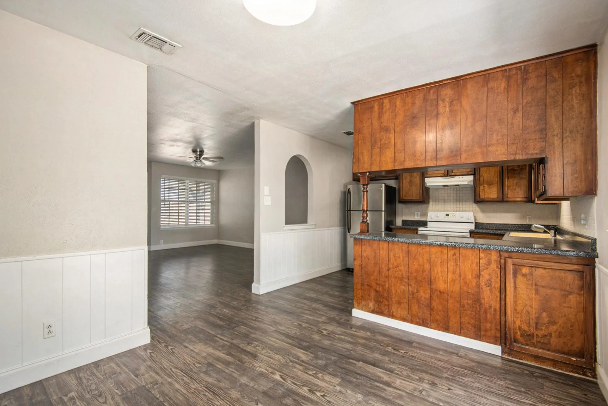 Kitchen bar with wood paneling and dark countertops