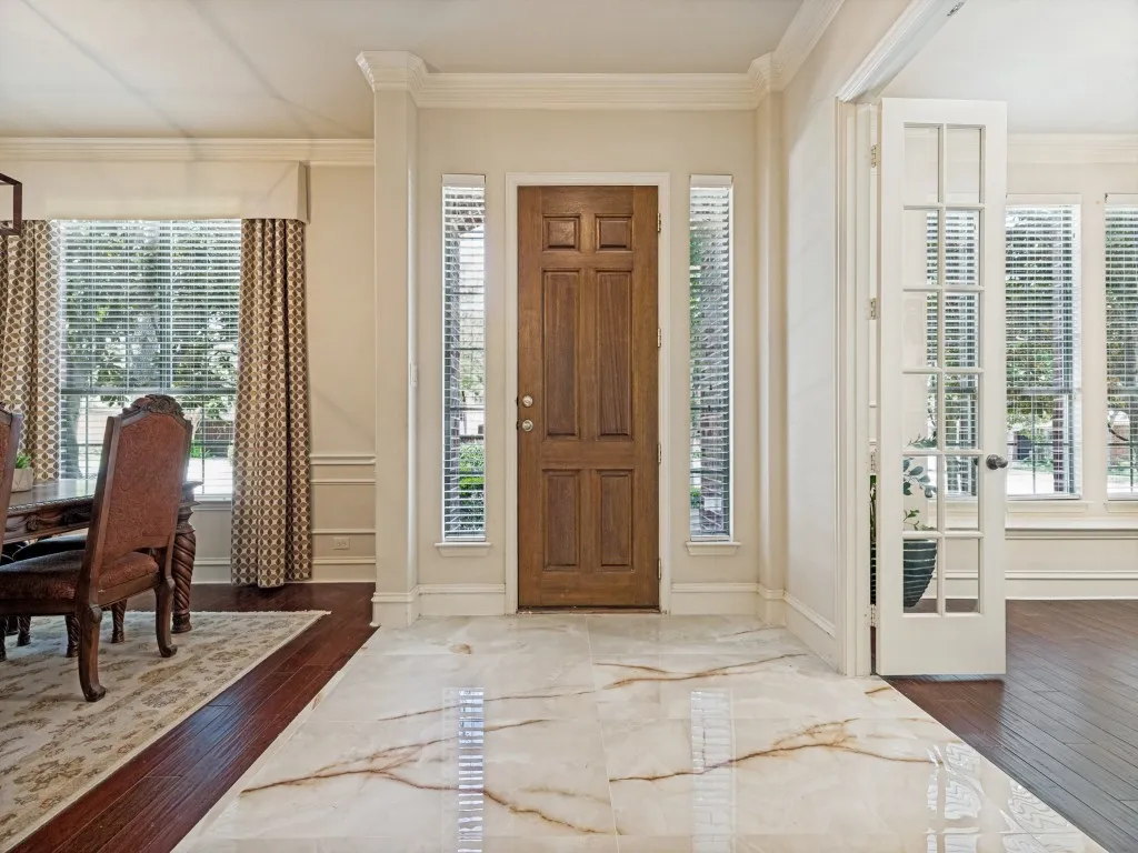 Warm wood-paneled entry door flanked by two vertical windows