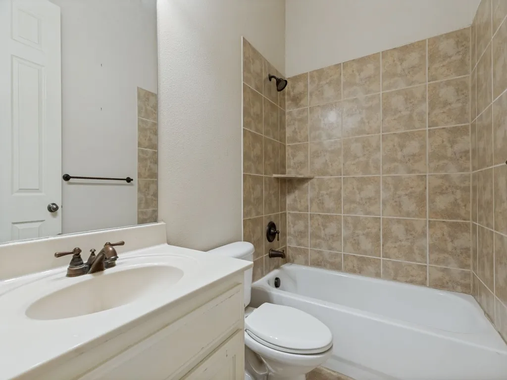 Bathroom featuring a white vanity with integrated sink, bronze-finish faucet, and coordinating towel bar