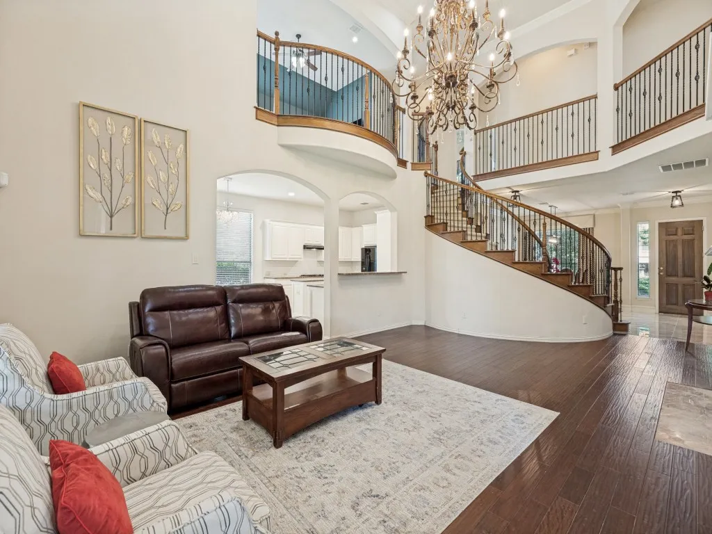 Two-story foyer featuring dark wood-finish flooring and a grand curved staircase with dark wood railings