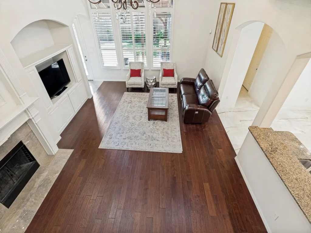 Living area featuring rich wood-finish flooring and a stone-surround fireplace with an integrated media cabinet