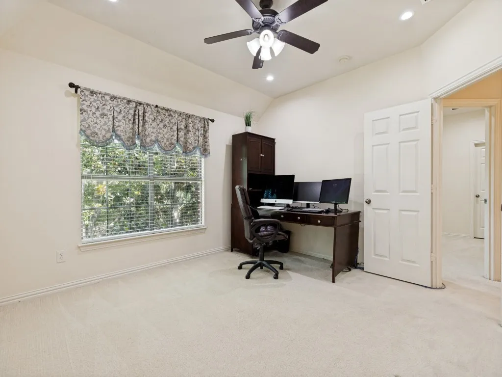 Bright room featuring an expansive window, vaulted ceiling, and recessed lighting