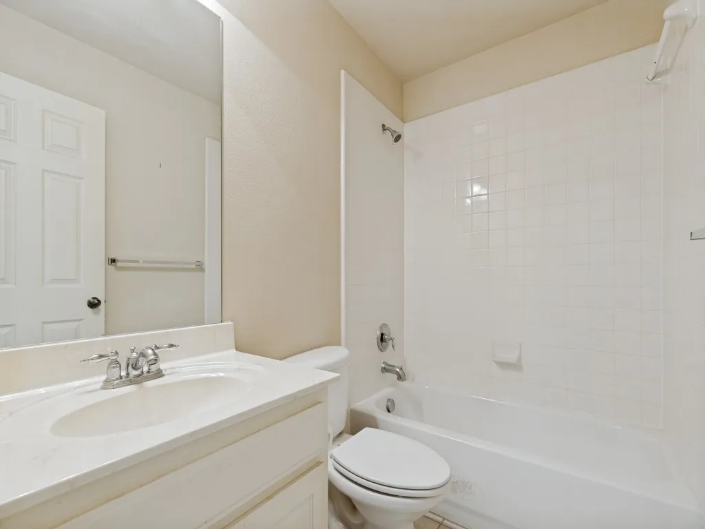 Bathroom featuring a single vanity with an integrated sink, polished chrome faucet, and a large wall-mounted mirror