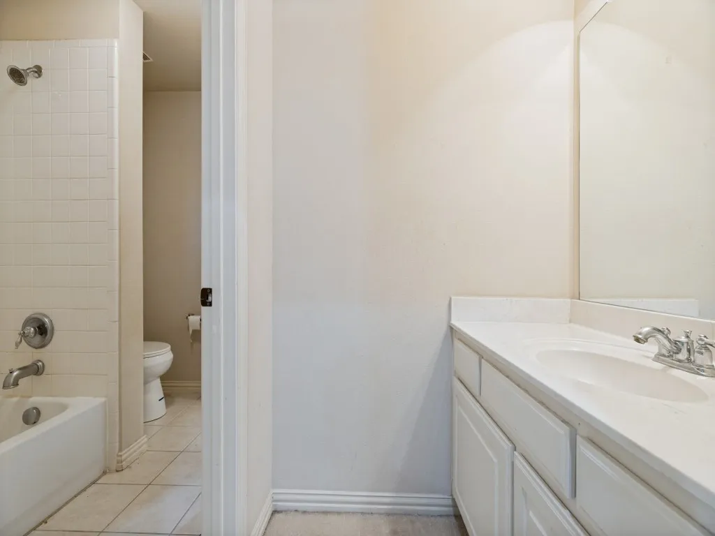 Bathroom vanity featuring a white countertop with an integrated sink and chrome faucet