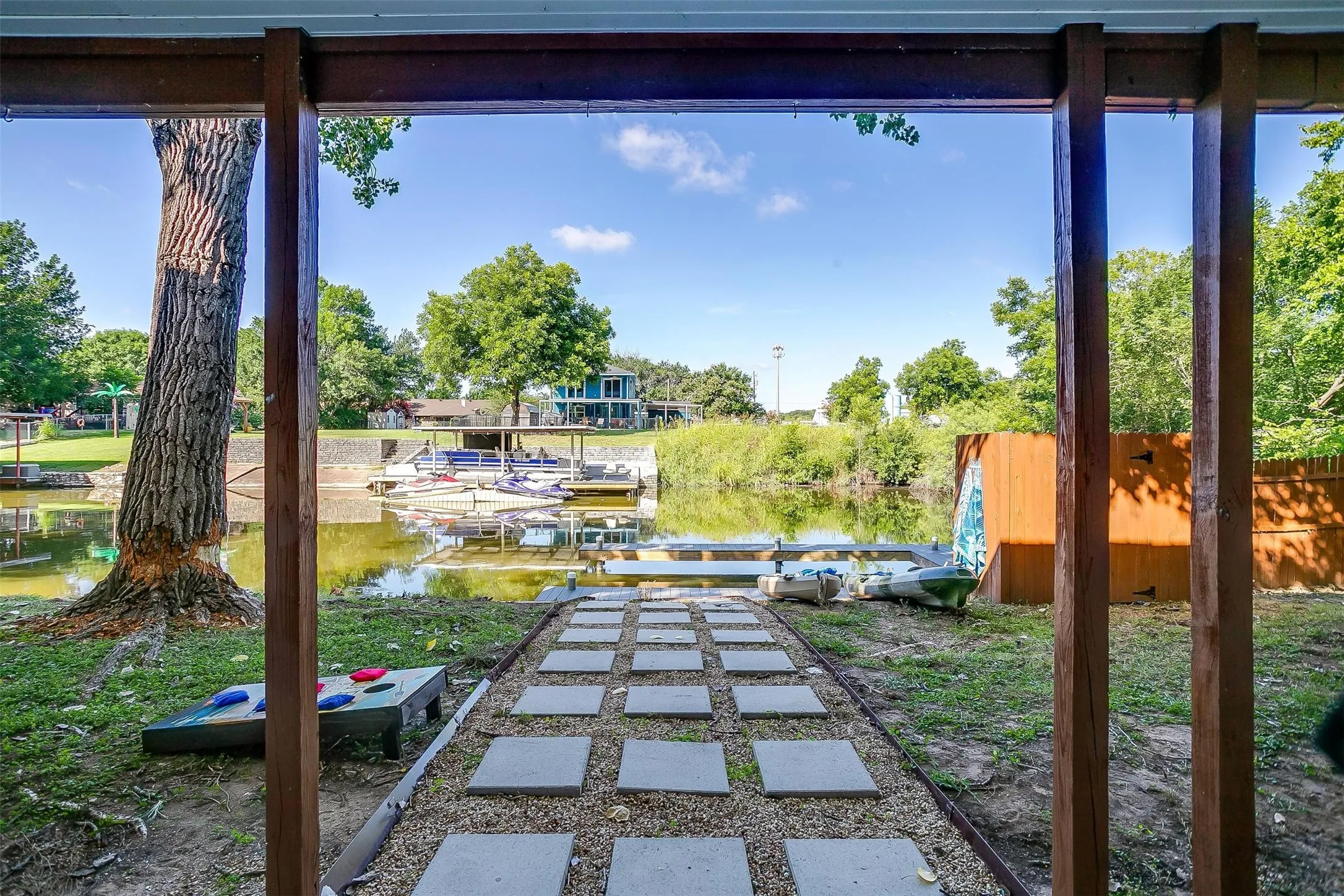 Waterfront setting with a stepping stone pathway leading to the water, surrounded by mature trees and natural landscaping
