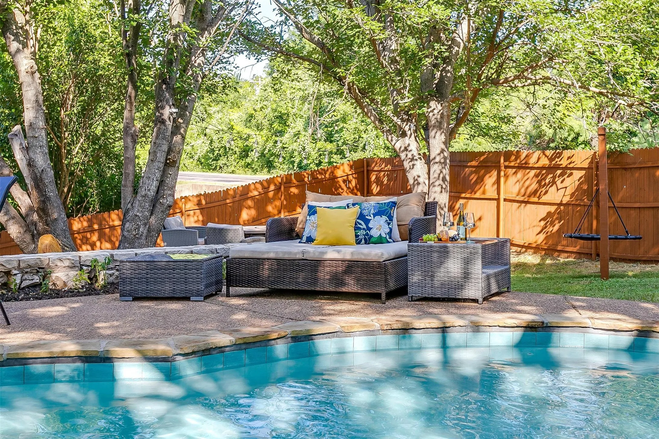 Sparkling swimming pool with a stone coping and a surrounding concrete patio