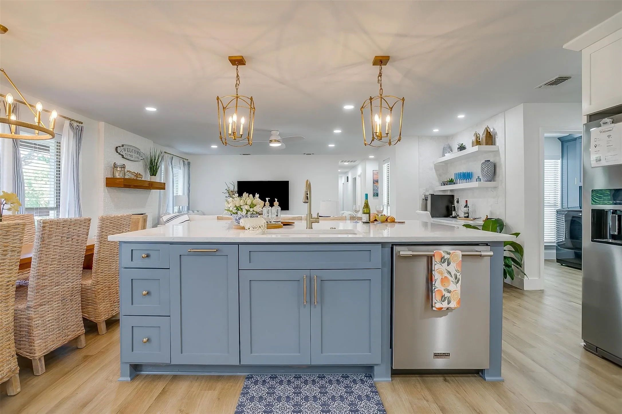 Spacious kitchen island with blue cabinetry and a light-toned countertop, featuring a stainless steel dishwasher