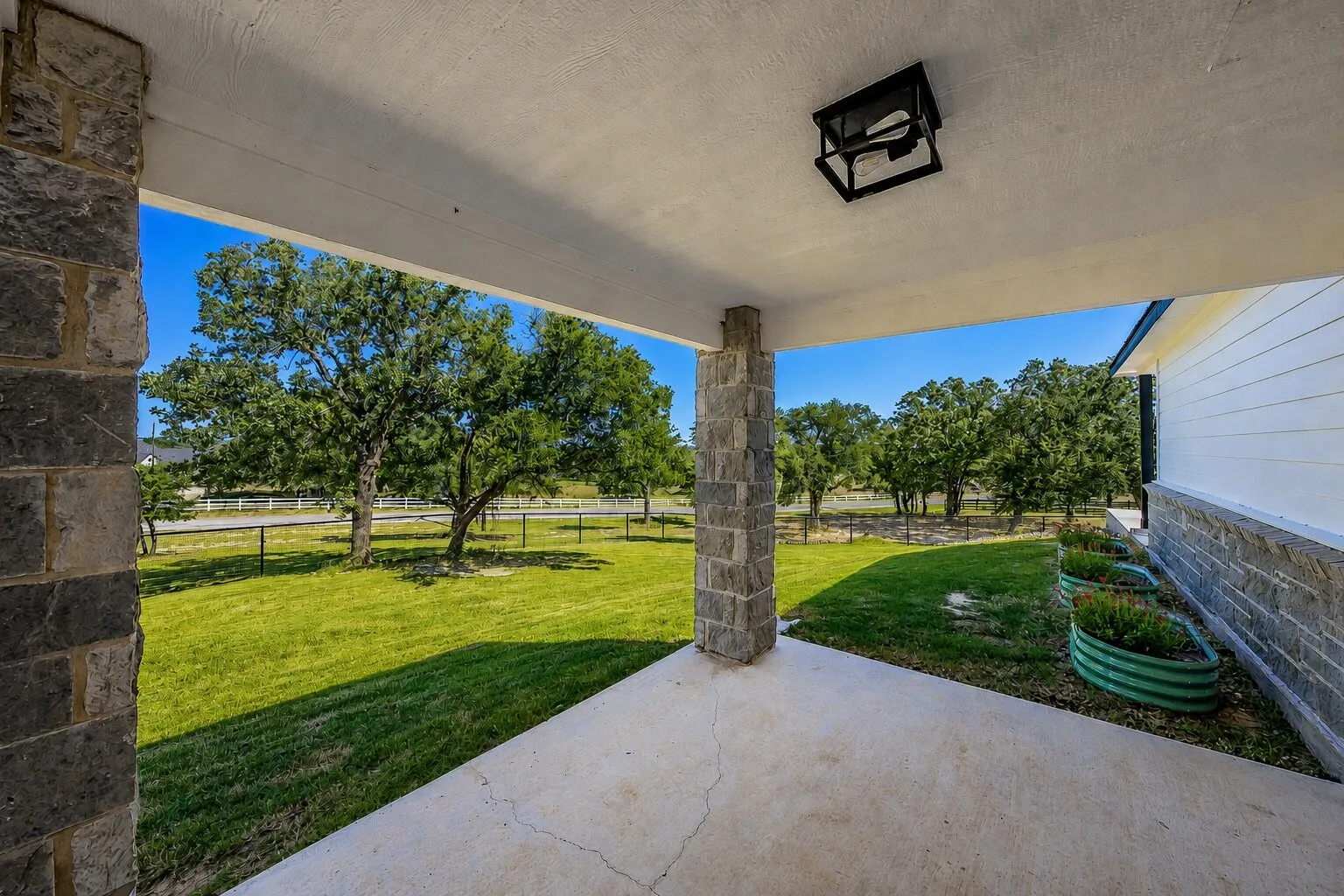 Covered patio with a concrete surface, stone pillar, and recessed ceiling light