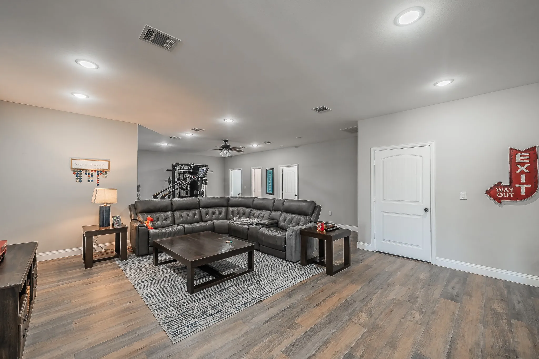 Spacious living area featuring wood-finish flooring, recessed lighting, and light gray wall paint